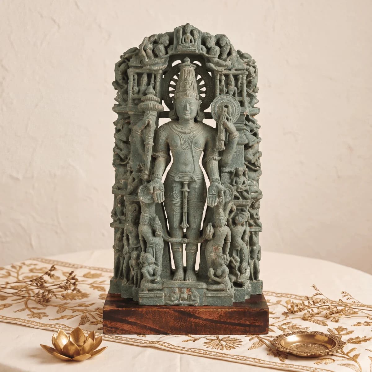 A front-facing view of the Chaturbhuj Vishnu Sculpture, a stone composite museum replica featuring intricate carvings on a wooden base.