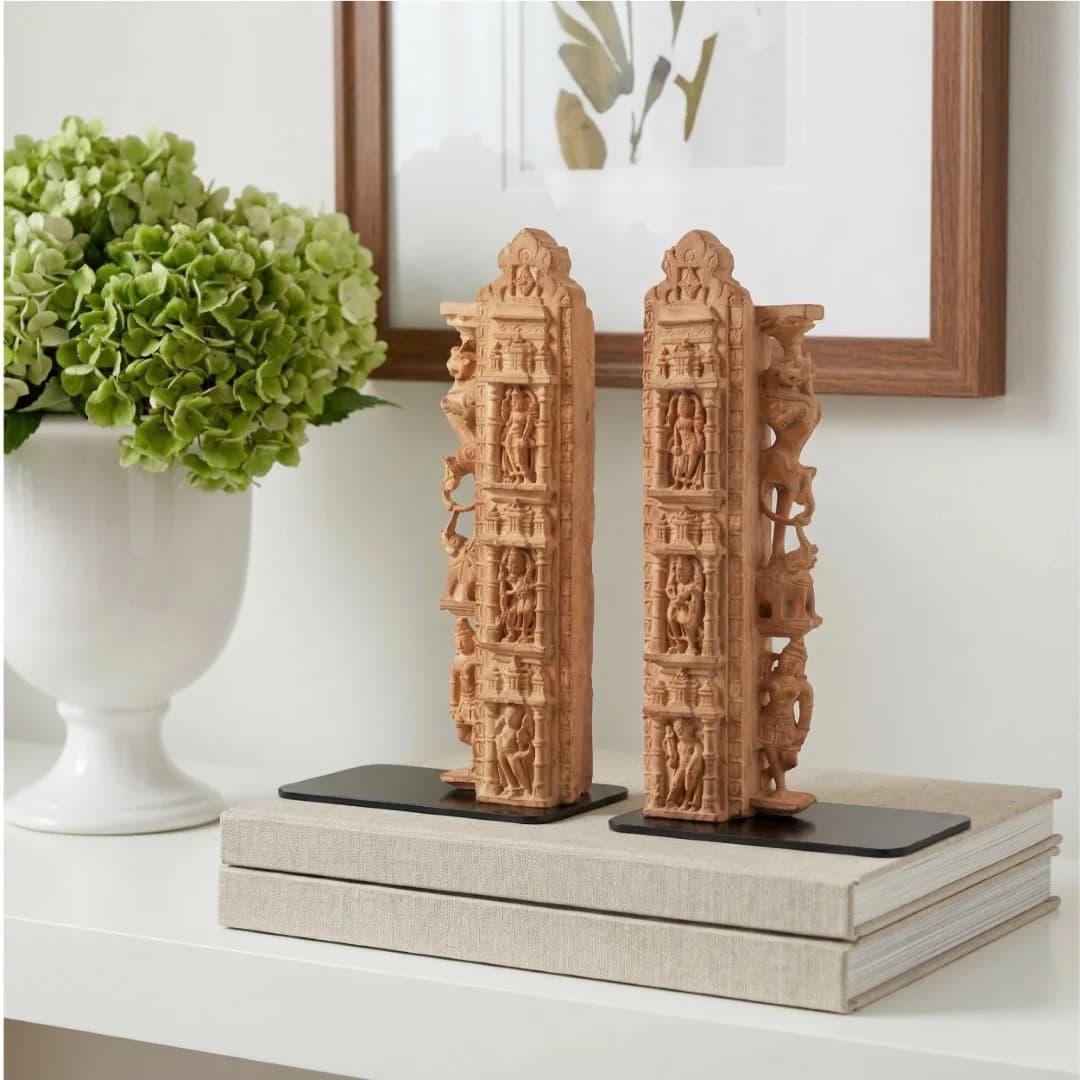 A pair of Dwara Shakha Sculpture bookends crafted from stone composite, featuring intricate temple carvings displayed on stacked books.