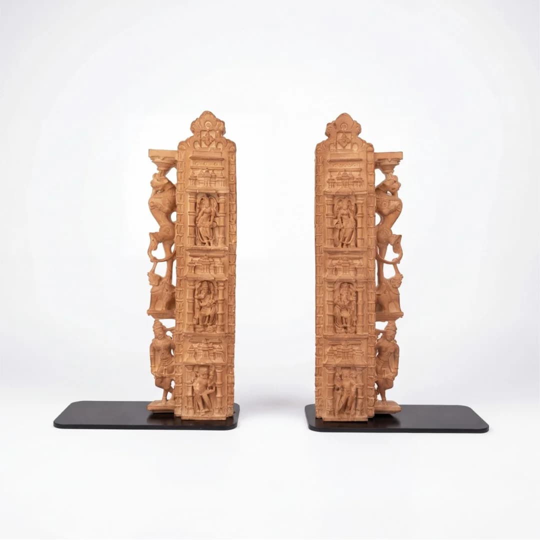 A pair of Dwara Shakha Sculpture bookends crafted from stone composite, featuring intricate temple door jamb carvings on black bases.