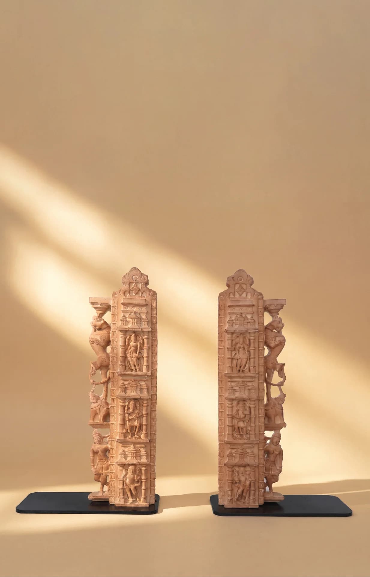A pair of stone composite Dwara Shakha Sculpture replicas featuring intricate celestial carvings, displayed upright on black bases.