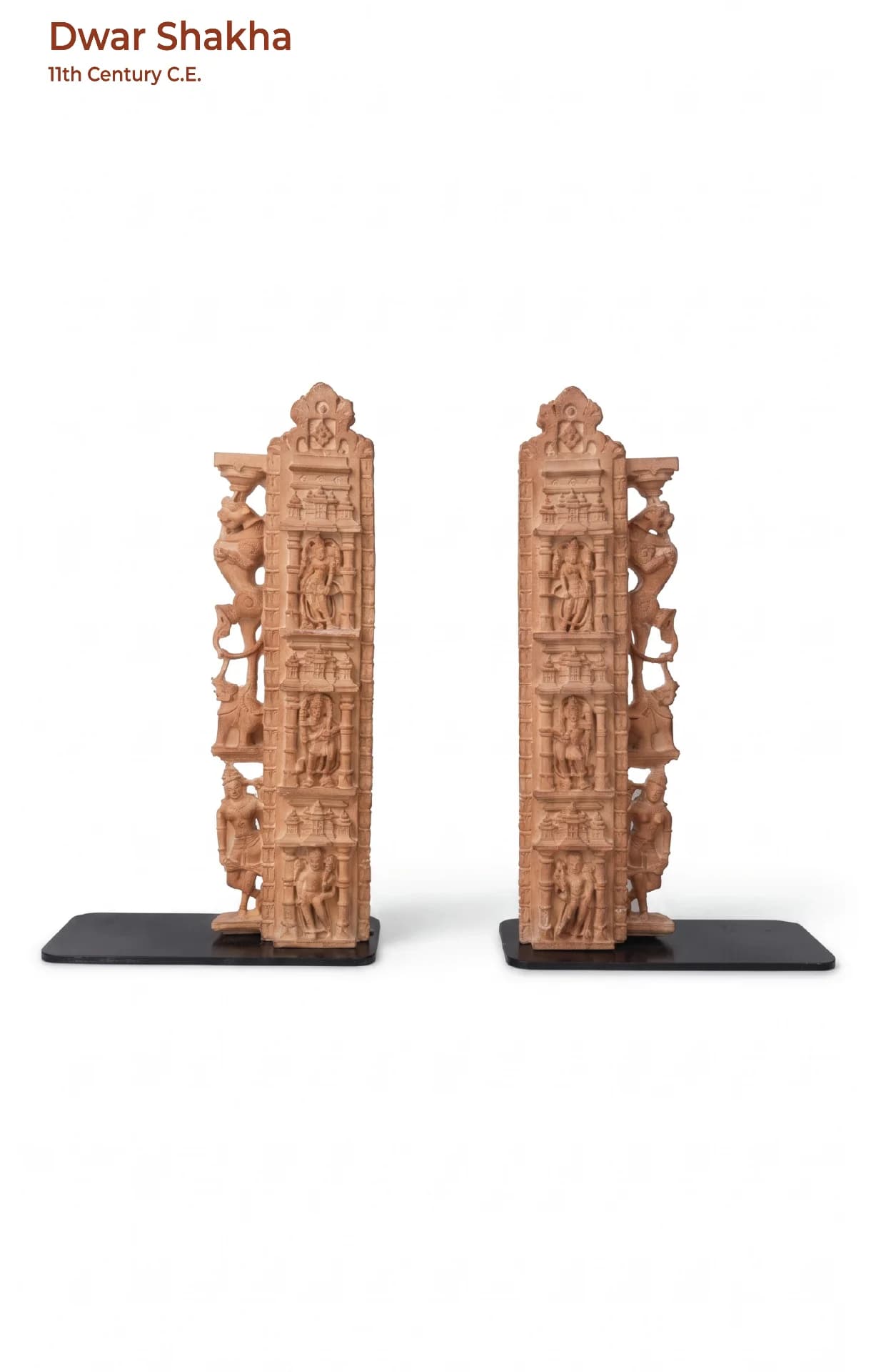 A pair of Dwar Shakha Sculpture bookends featuring intricate stone composite carvings of celestial figures on black bases.
