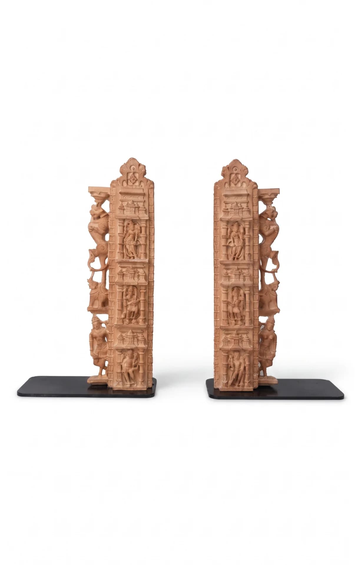 A pair of Dwara Shakha Sculpture bookends crafted from stone composite, featuring intricate celestial carvings on black metal bases.