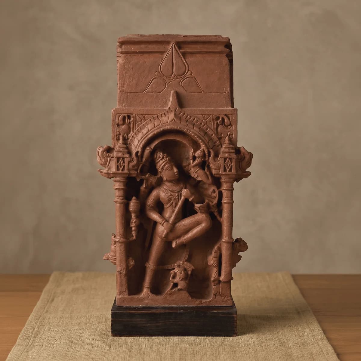 A front view of the Gajasura Vadha Sculpture, a terracotta-style museum replica showing intricate temple relief carvings of Shiva.