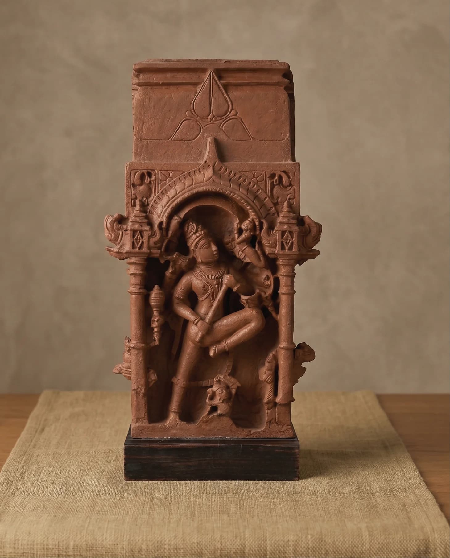 A front-facing studio shot of the Gajasura Vadha Sculpture, a terracotta-style museum replica featuring intricate temple relief carvings of Shiva.