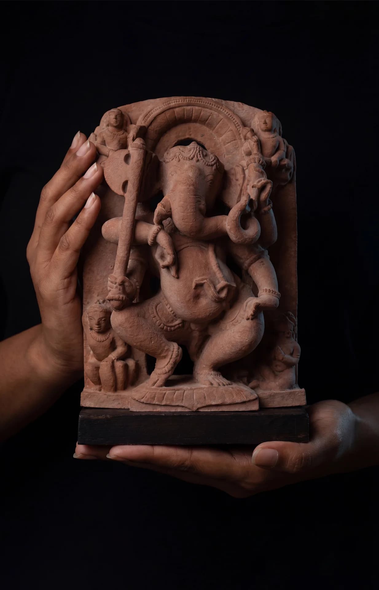 Two hands hold a stone composite Ganesha Sculpture, showcasing the intricate details of this 10th-century museum replica artifact.