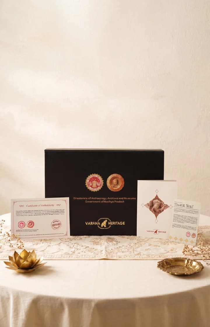 The Ganesha Sculpture packaging set includes a black presentation box, certificate of authenticity, and thank you note on a table.