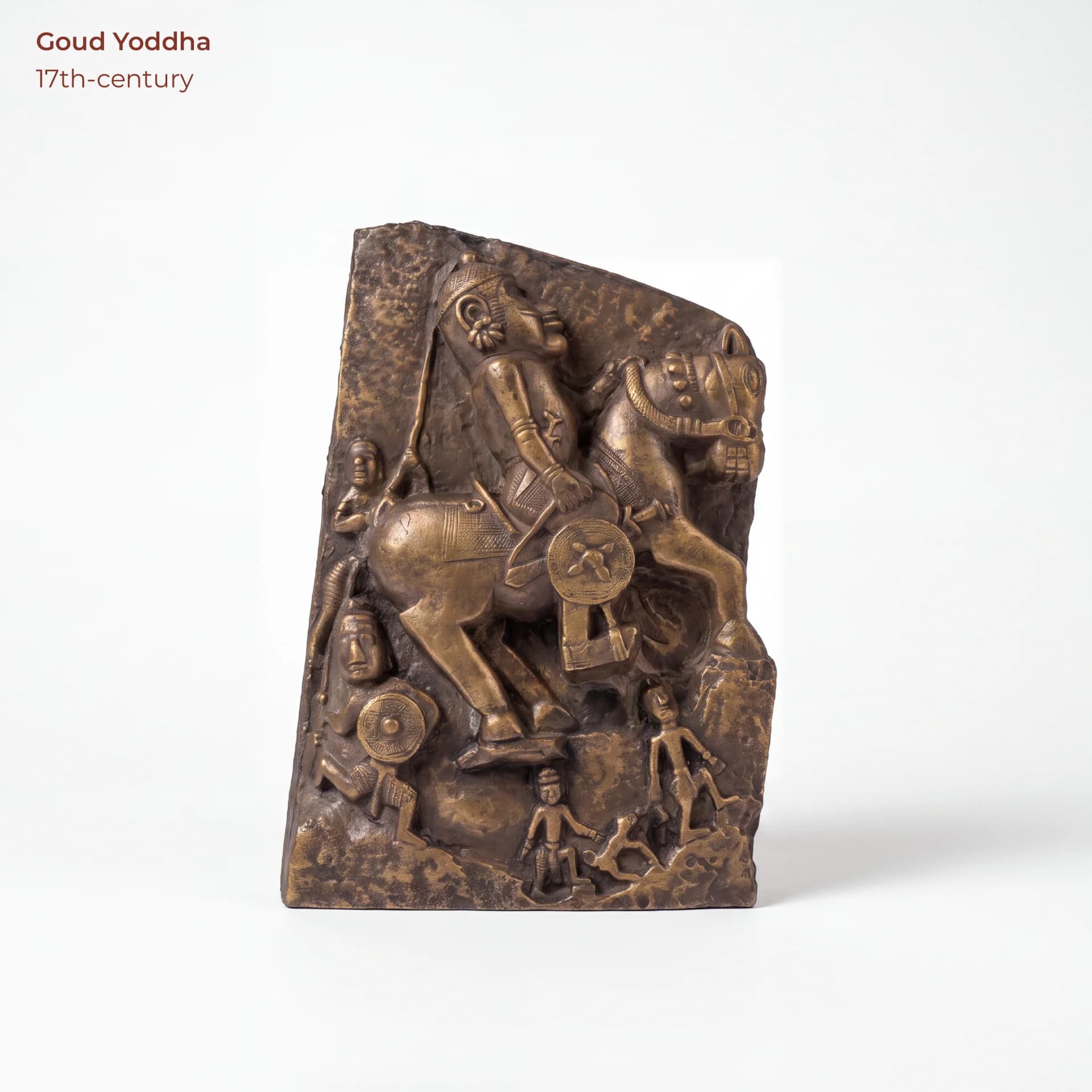 A bronze-finish Goud Yoddha relief sculpture showing a warrior on horseback surrounded by smaller figures in traditional style.