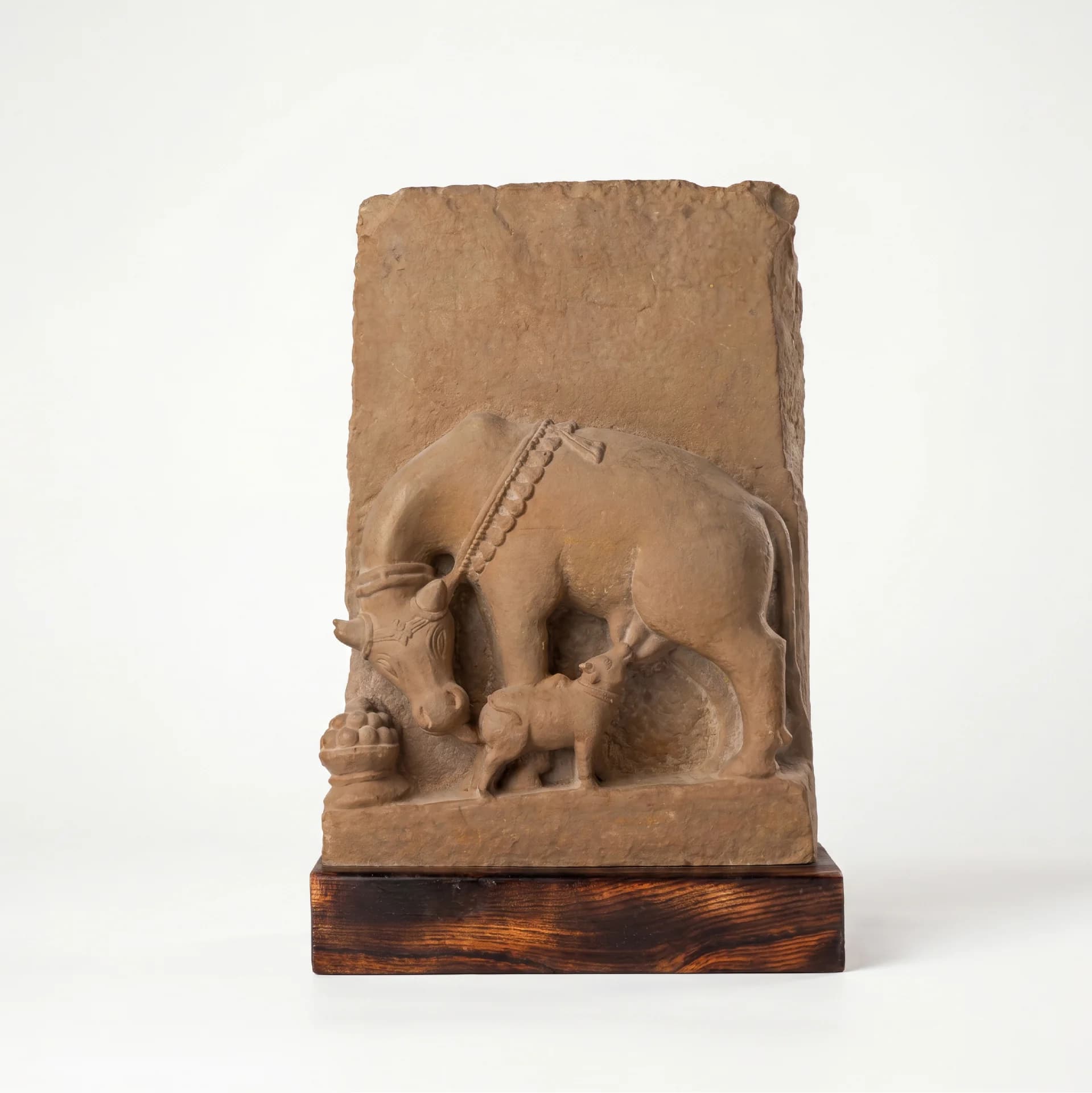A front view of the Kamdhenu Sculpture, a hand-finished stone composite replica depicting the divine cow nursing her calf.
