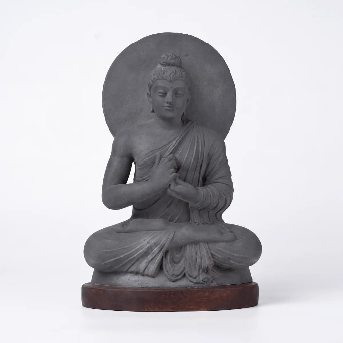 A front-facing view of the Preaching Buddha statue, crafted in a dark stone composite with Gandhara-style artistic details.