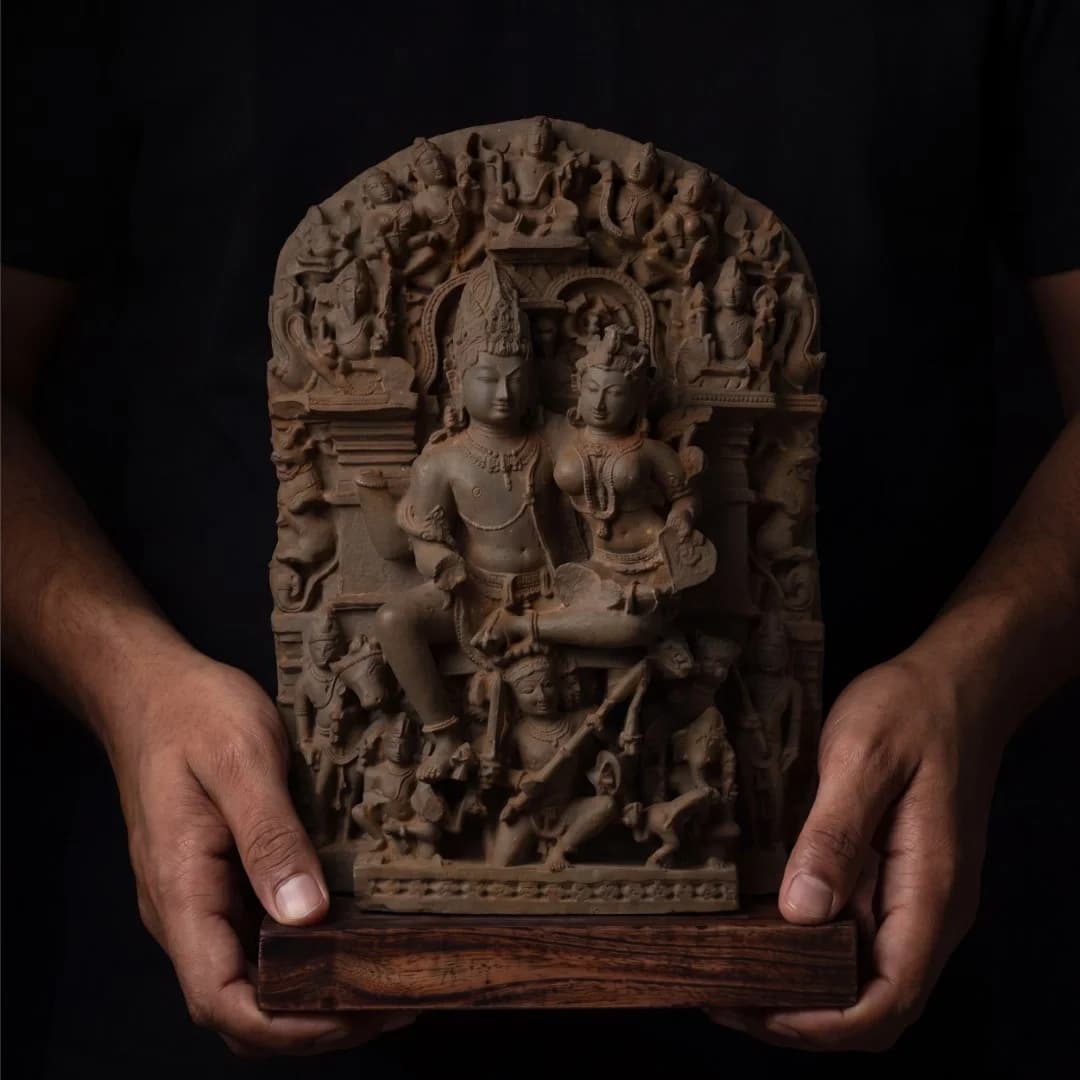 A person holds a stone composite Ravananugraha Sculpture, showcasing the intricate 11th-century temple art replica against a dark background.