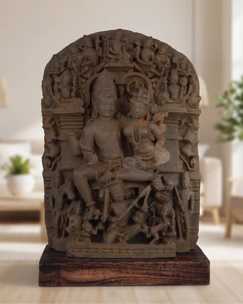 A front-facing view of the Ravananugraha Sculpture, a hand-finished stone composite replica featuring intricate divine figures on a teak base.