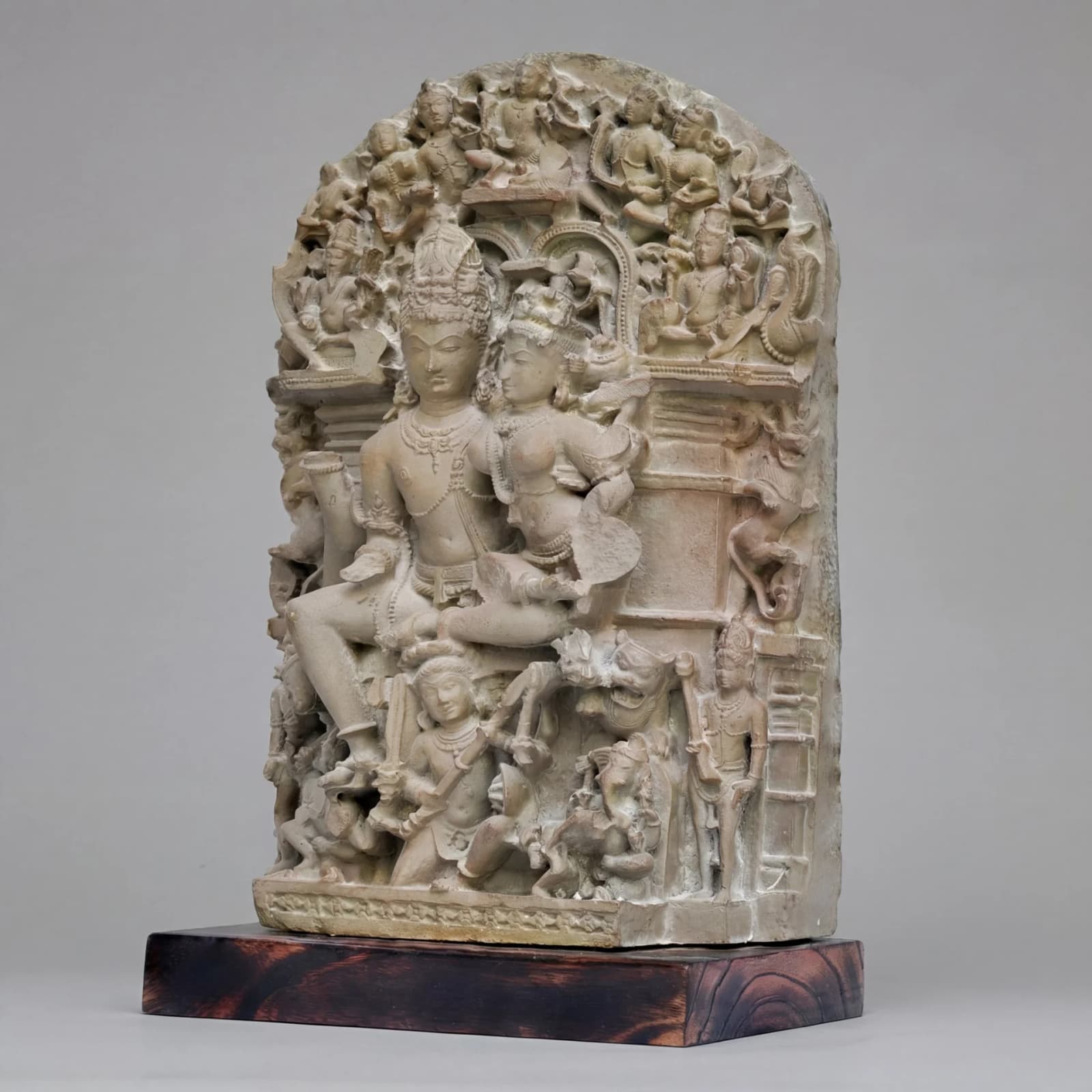 A three-quarter view of the stone composite Ravananugraha Sculpture, showcasing intricate 11th-century style carvings on a wooden base.