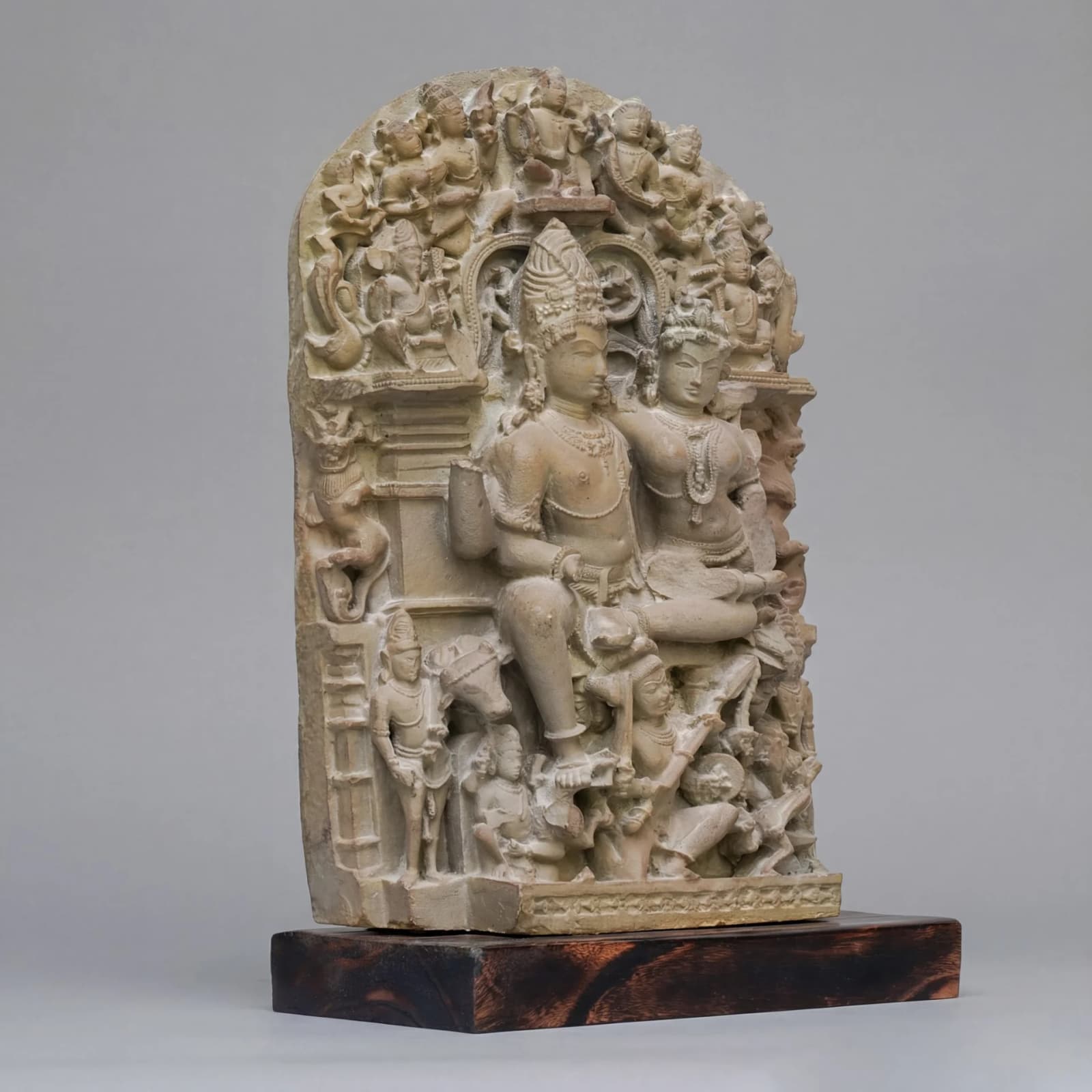 A three-quarter view of the stone composite Ravananugraha Sculpture, showcasing intricate 11th-century style carvings on a wooden base.