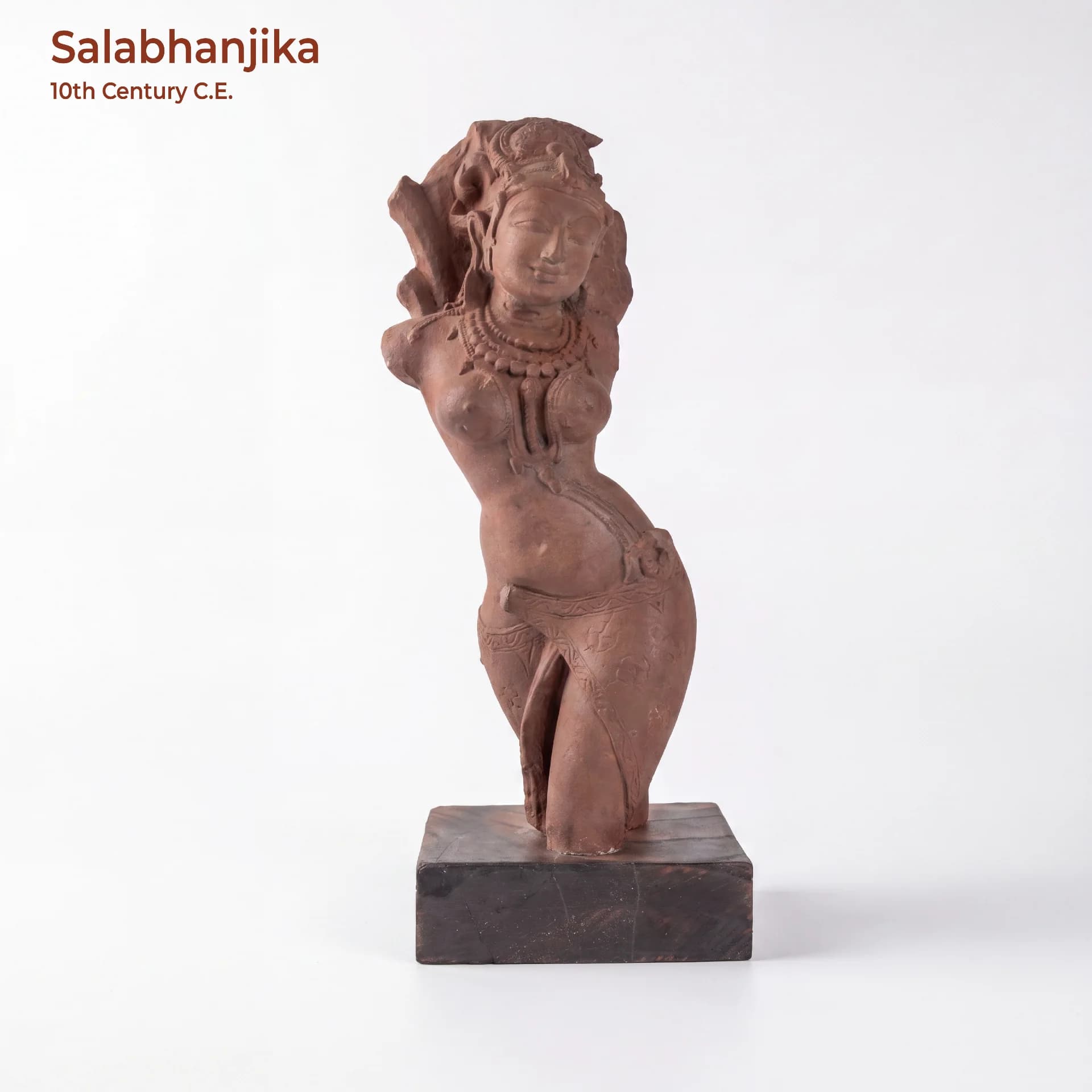 A front-facing view of the Salabhanjika Sculpture, a hand-finished stone composite replica featuring an elegant tribhanga pose on a wooden base.