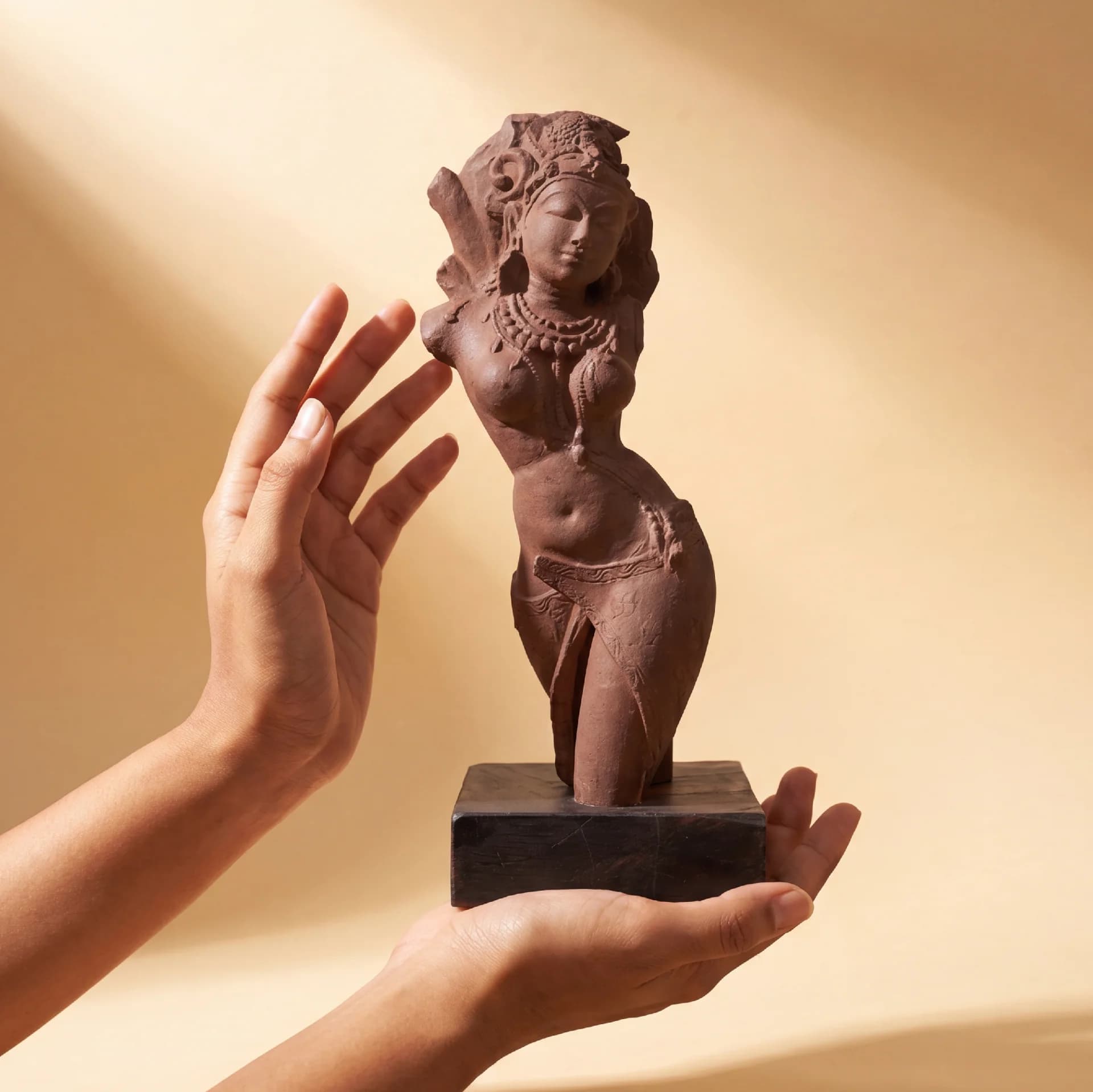 Hands gently cradle the stone composite Salabhanjika Sculpture, highlighting the elegant tribhanga pose of this 10th-century museum replica.