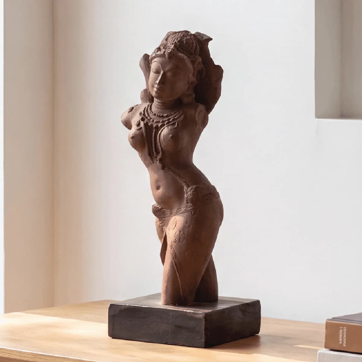 A three-quarter view of the Salabhanjika Sculpture, a stone composite museum replica standing elegantly on a dark wooden base.