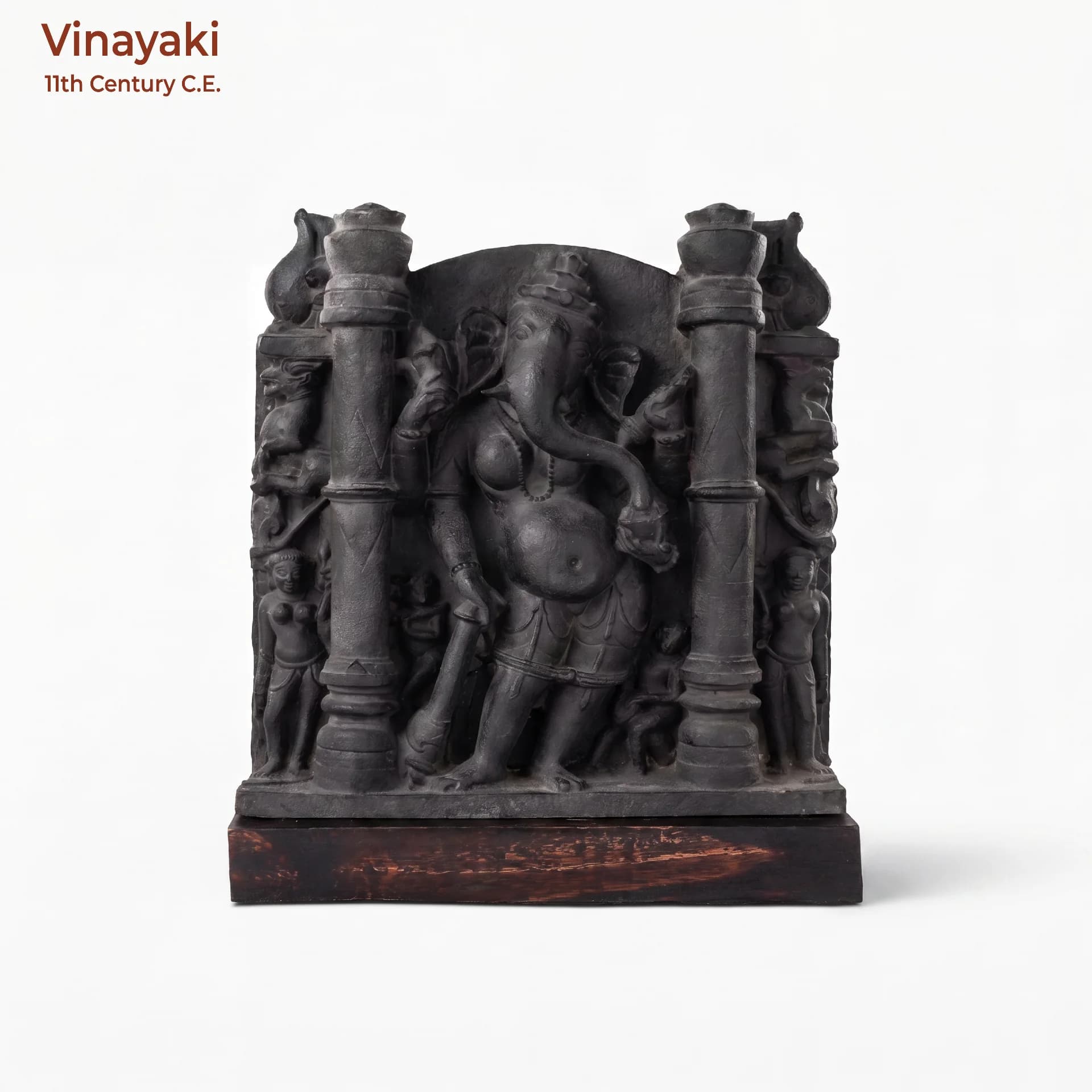 A front-facing view of the Vinayaki Sculpture, a dark stone museum replica featuring intricate early medieval Indian temple iconography.