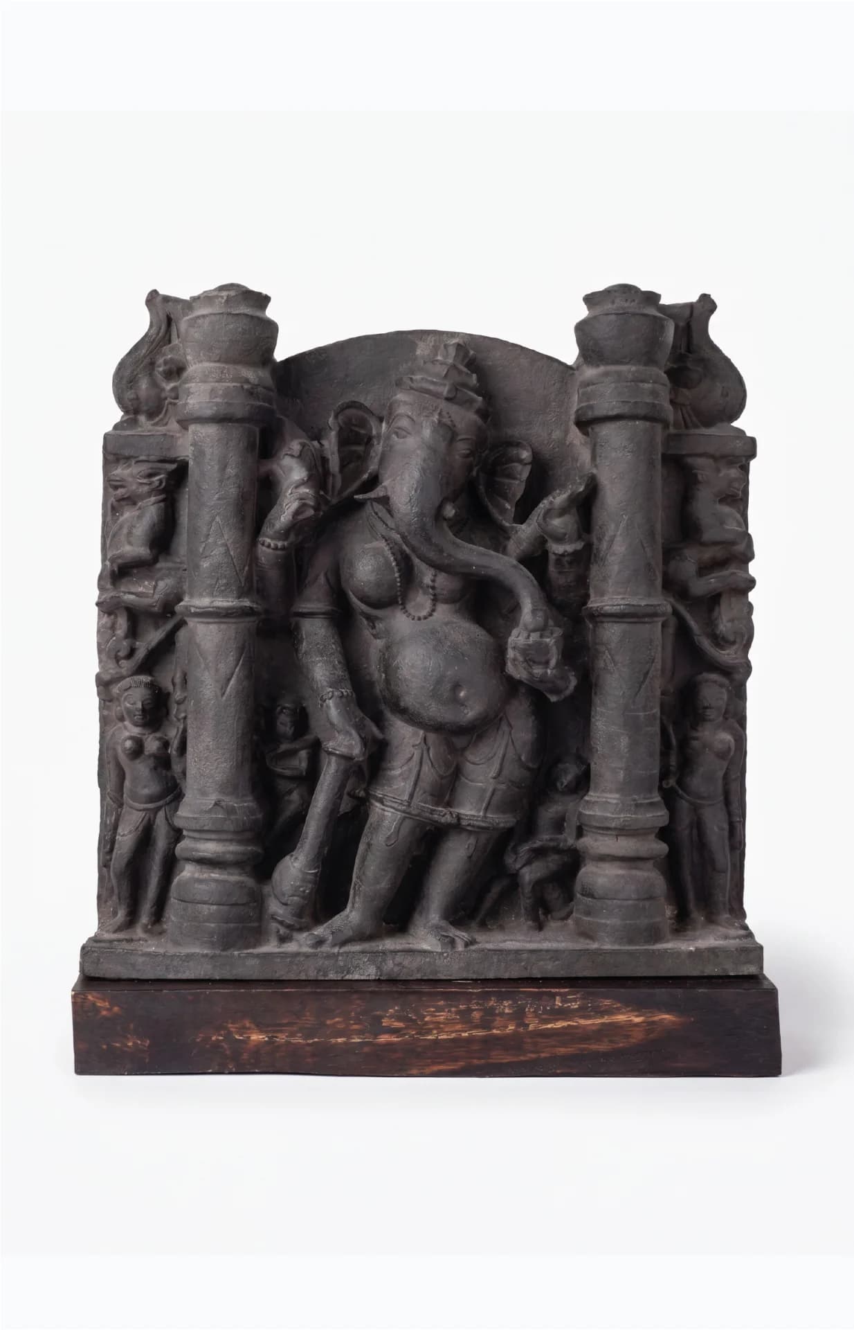 A front-facing view of the Vinayaki Sculpture, a dark stone museum replica featuring intricate 11th-century Hindu temple iconography.