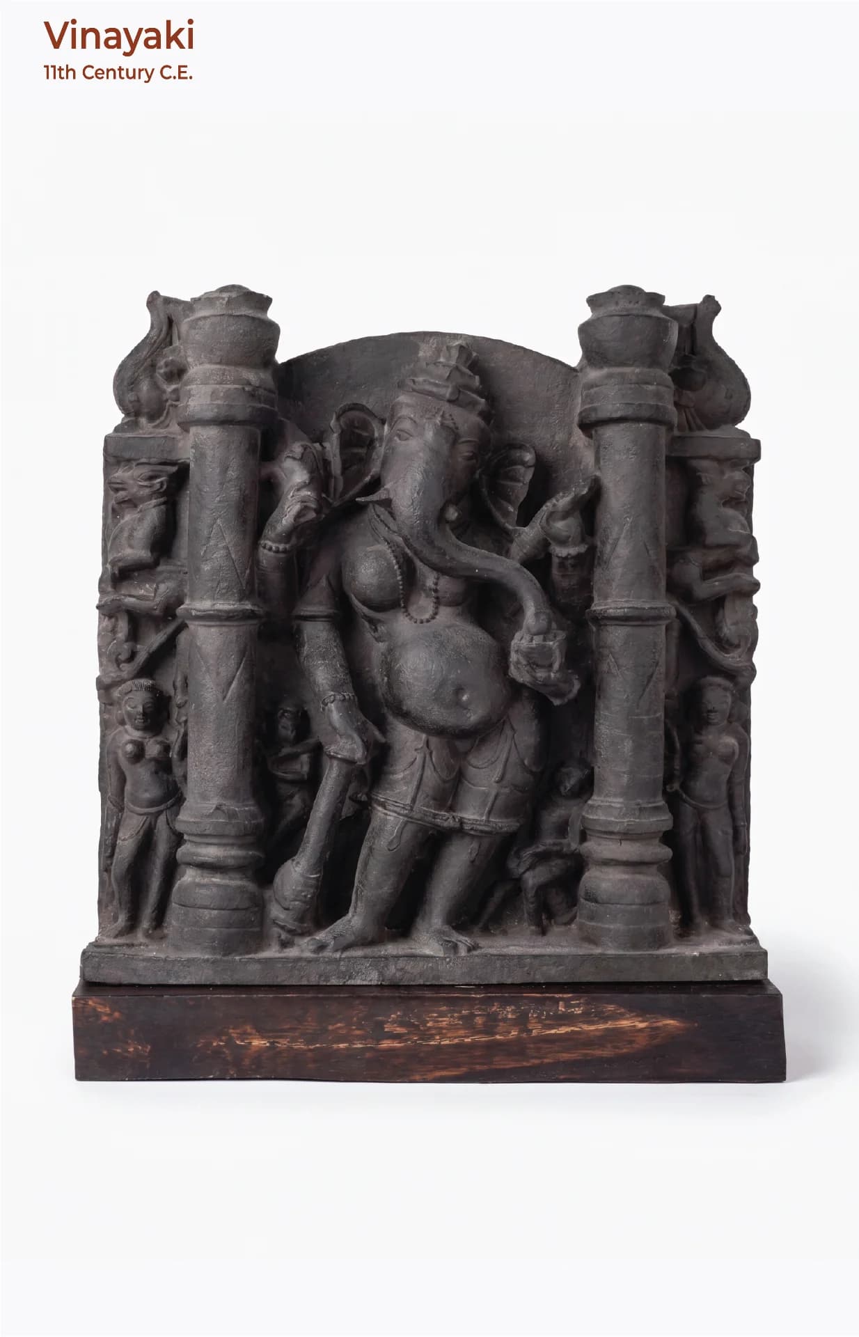 A front-facing view of the Vinayaki Sculpture, a dark stone museum replica featuring intricate early medieval Indian temple iconography.