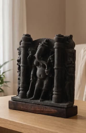 A three-quarter view of the Vinayaki Sculpture, a dark stone museum replica featuring intricate medieval Indian temple iconography.