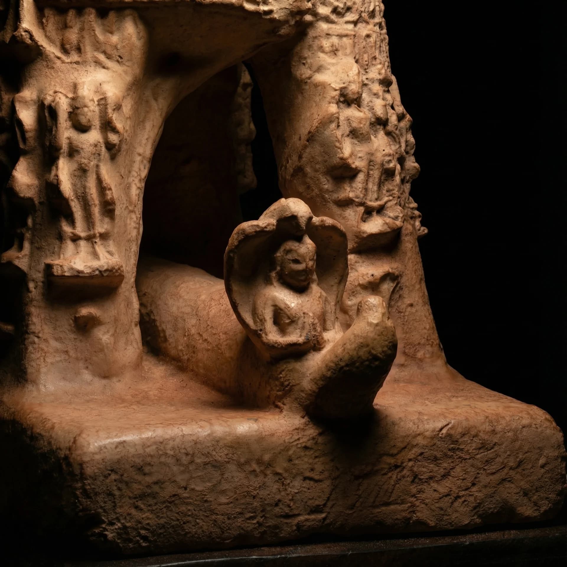 A detailed low-angle view of the Adi Varaha Sculpture, showcasing the weathered sandstone texture and intricate carved figures.