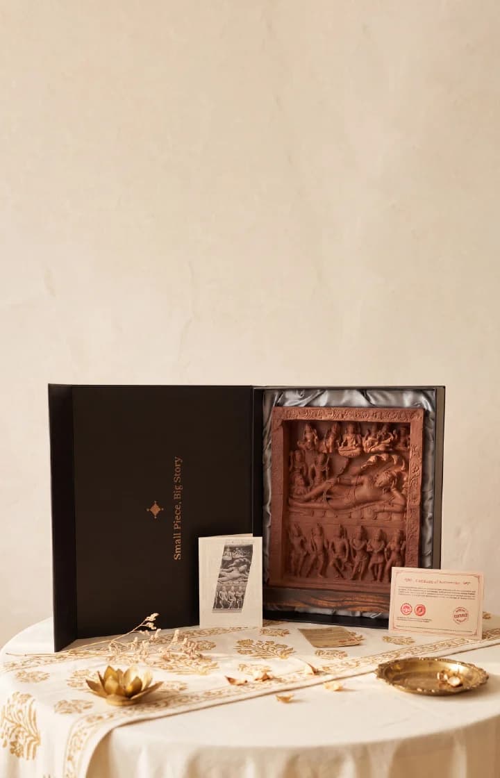 An Anantasayana Vishnu Sculpture museum replica displayed in an open black gift box with an authenticity certificate on a table.