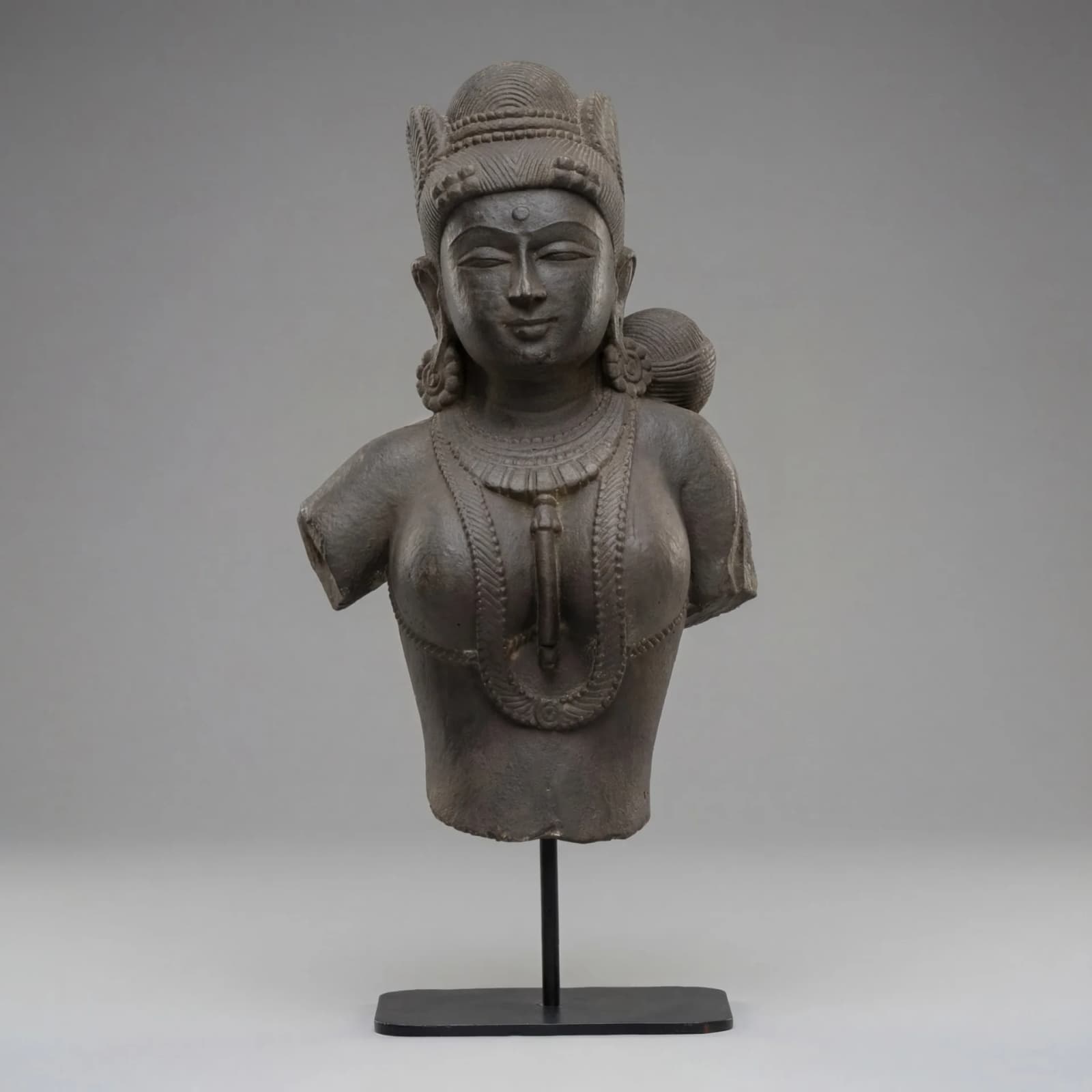 A front-view of the Female Figure Bust Sculpture, a stone composite replica showcasing intricate Chola style jewelry and craftsmanship.