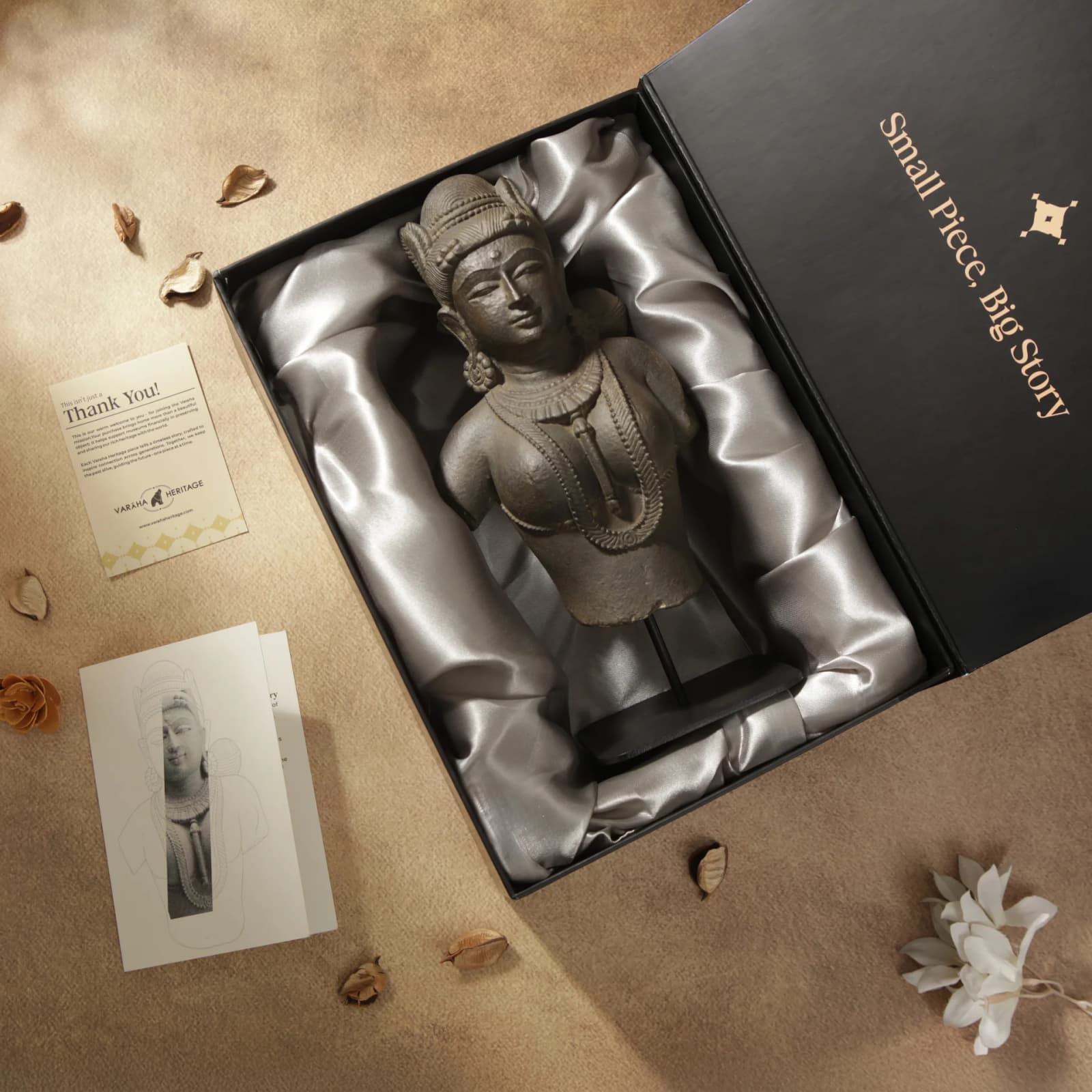 A Female Figure Bust Sculpture in Chola style rests inside a gift box lined with silver satin fabric.