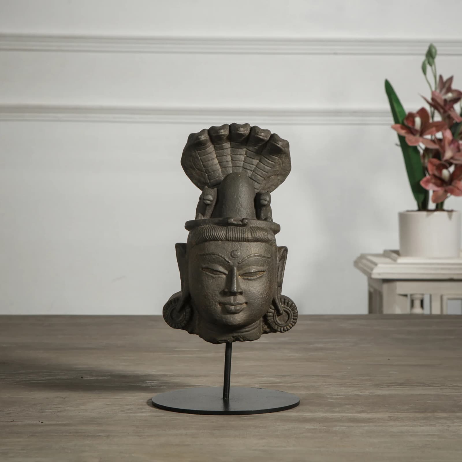 A stone composite Shiva Lingam with Nandi & Serpent replica featuring a serene deity head on a metal display stand.