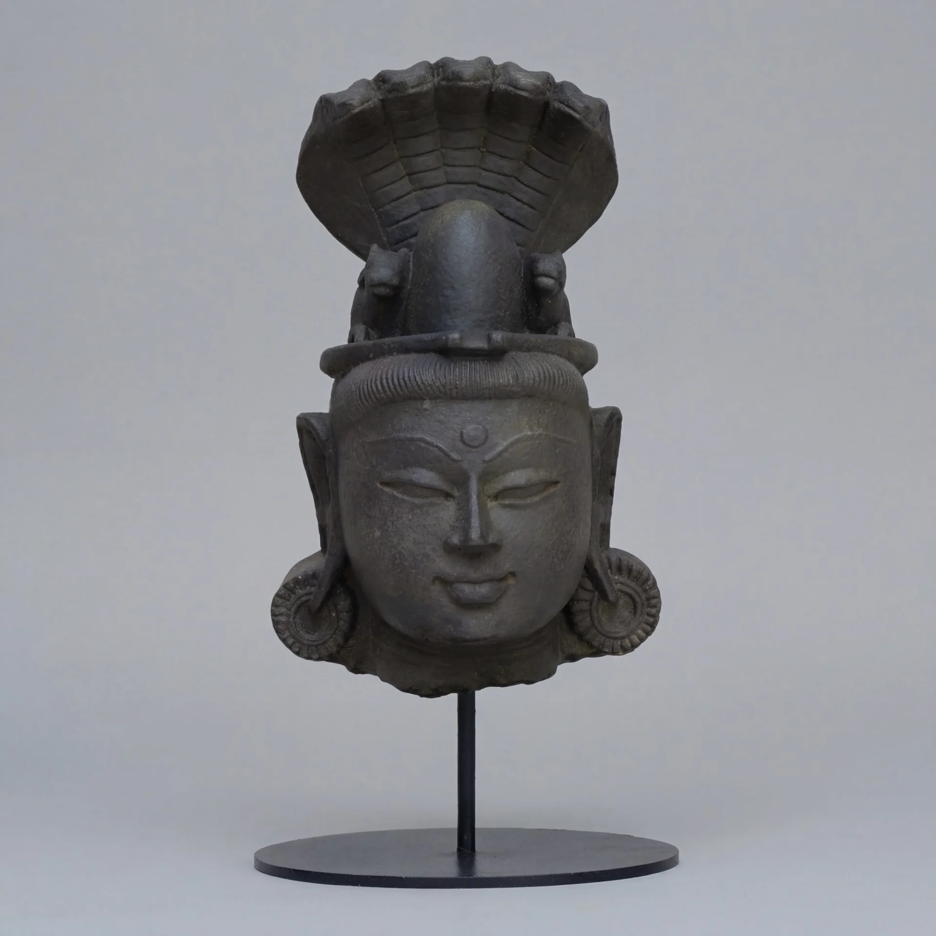 A front-facing view of the Shiva Lingam with Nandi & Serpent replica, featuring intricate stone composite carving on a stand.