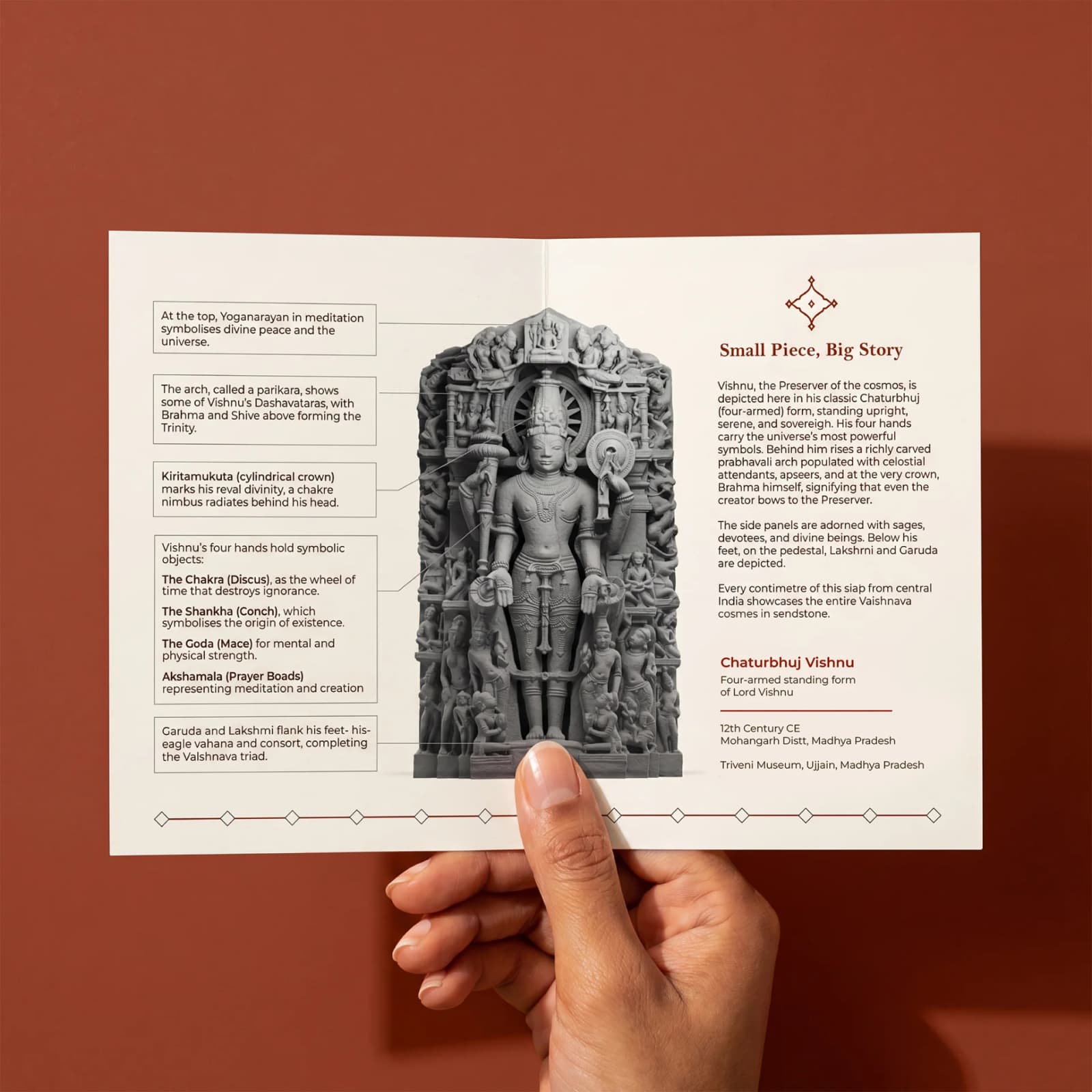 A hand holds an informational brochure about the Chaturbhuj Vishnu Sculpture, featuring detailed stone composite iconography and historical context.