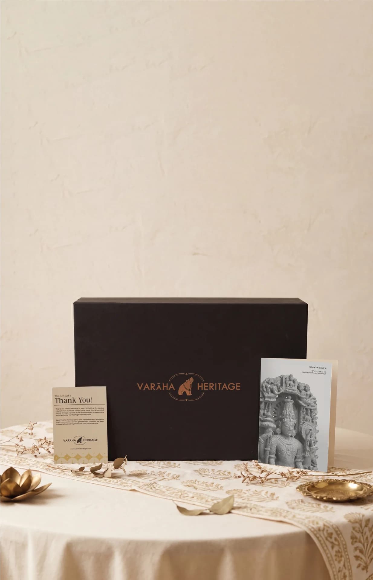 A black gift box for the Chaturbhuj Vishnu Sculpture, featuring a stone composite texture and accompanying heritage information cards.