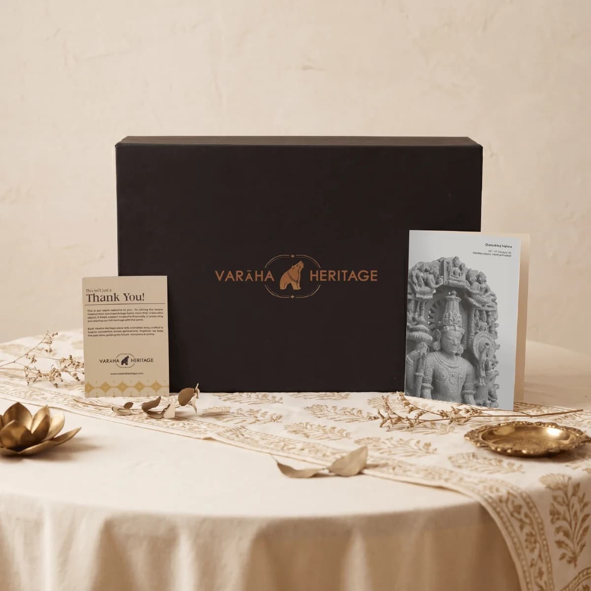 A black Varaha Heritage gift box displayed with a Chaturbhuj Vishnu Sculpture museum replica card and thank you note.