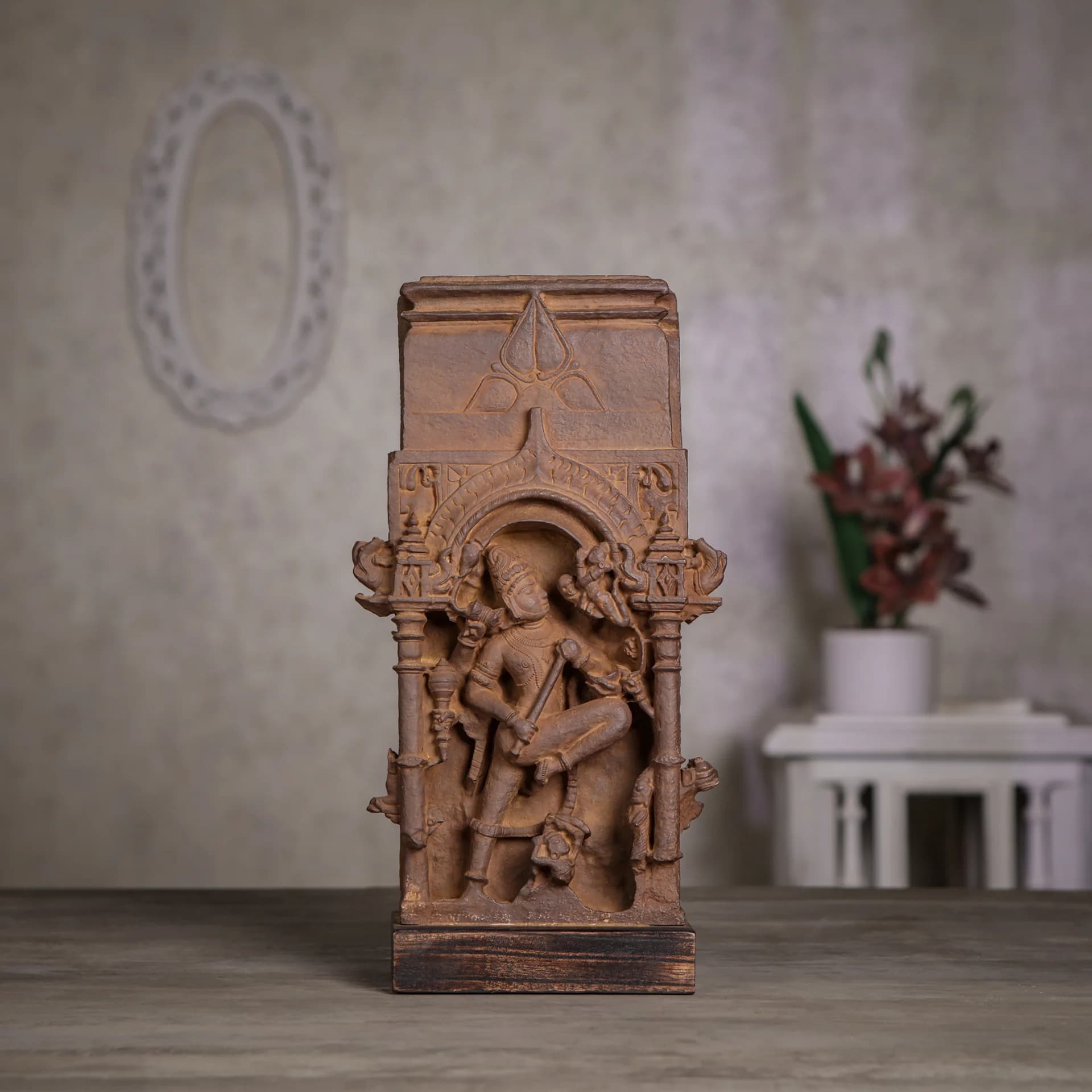 A front-facing view of the Gajasura Vadha Sculpture, a stone composite replica featuring intricate temple relief carvings of Lord Shiva.