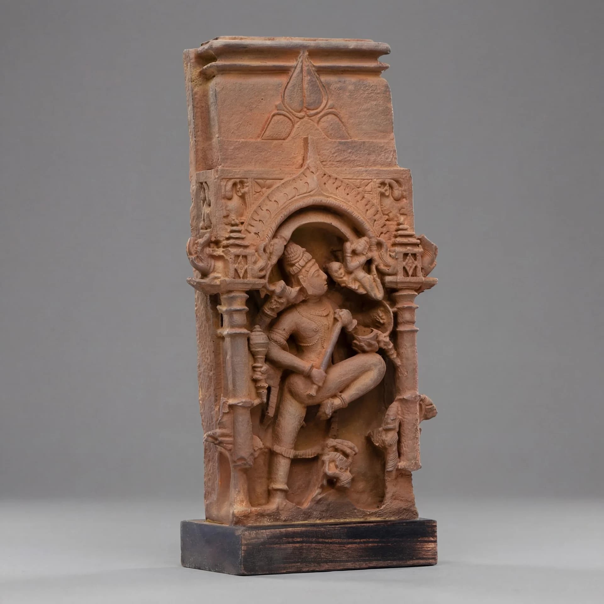 A three-quarter view of the Gajasura Vadha Sculpture, a stone composite replica featuring detailed temple relief carvings of Shiva.