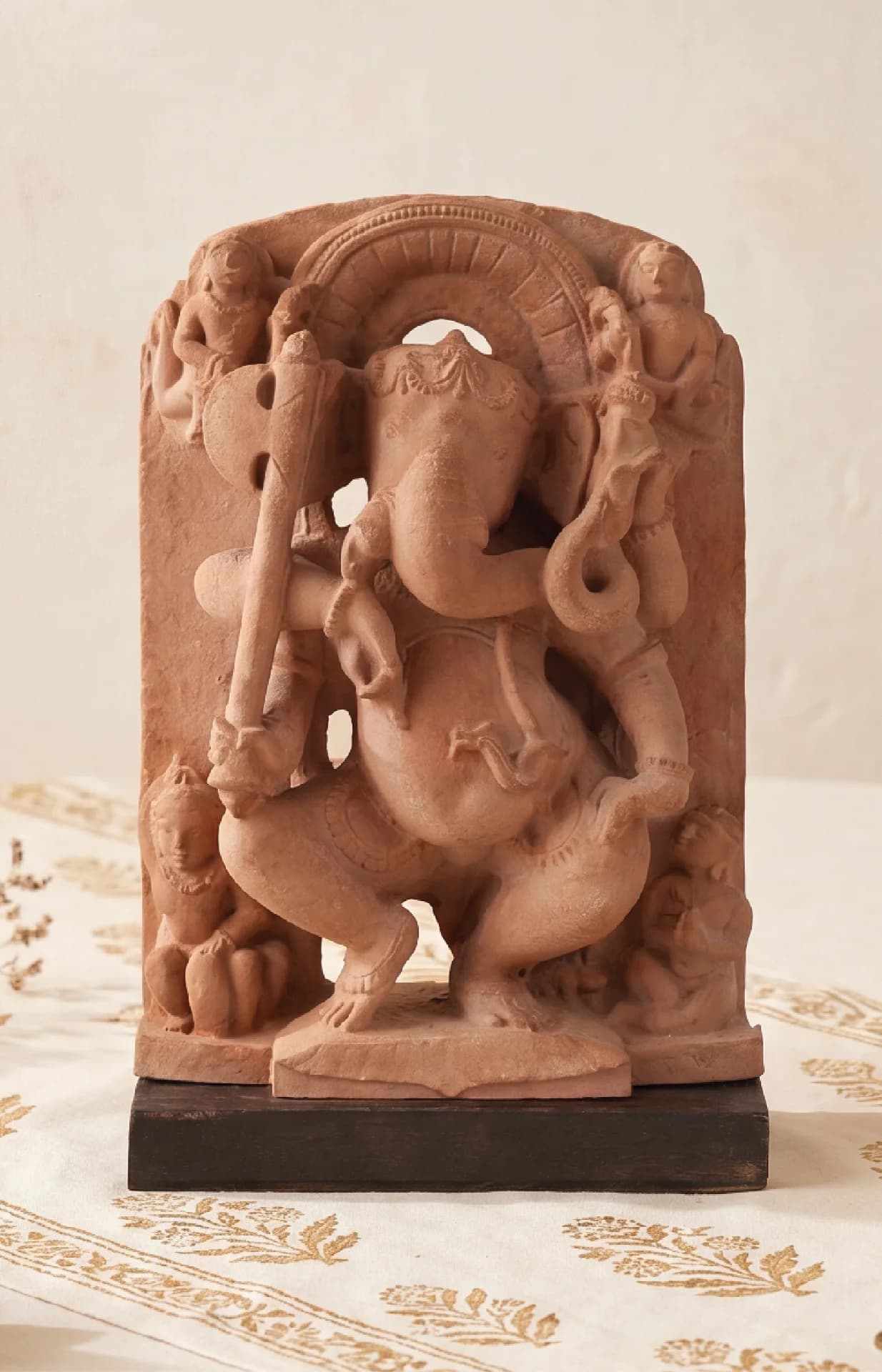 A front-facing view of the Ganesha Sculpture, a stone composite museum replica showing the deity dancing with attendants.