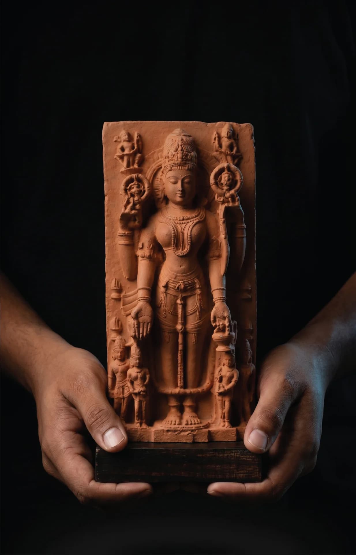 A pair of hands holds a stone composite Gauri Parvati Sculpture, showcasing the intricate details of the four-armed goddess.