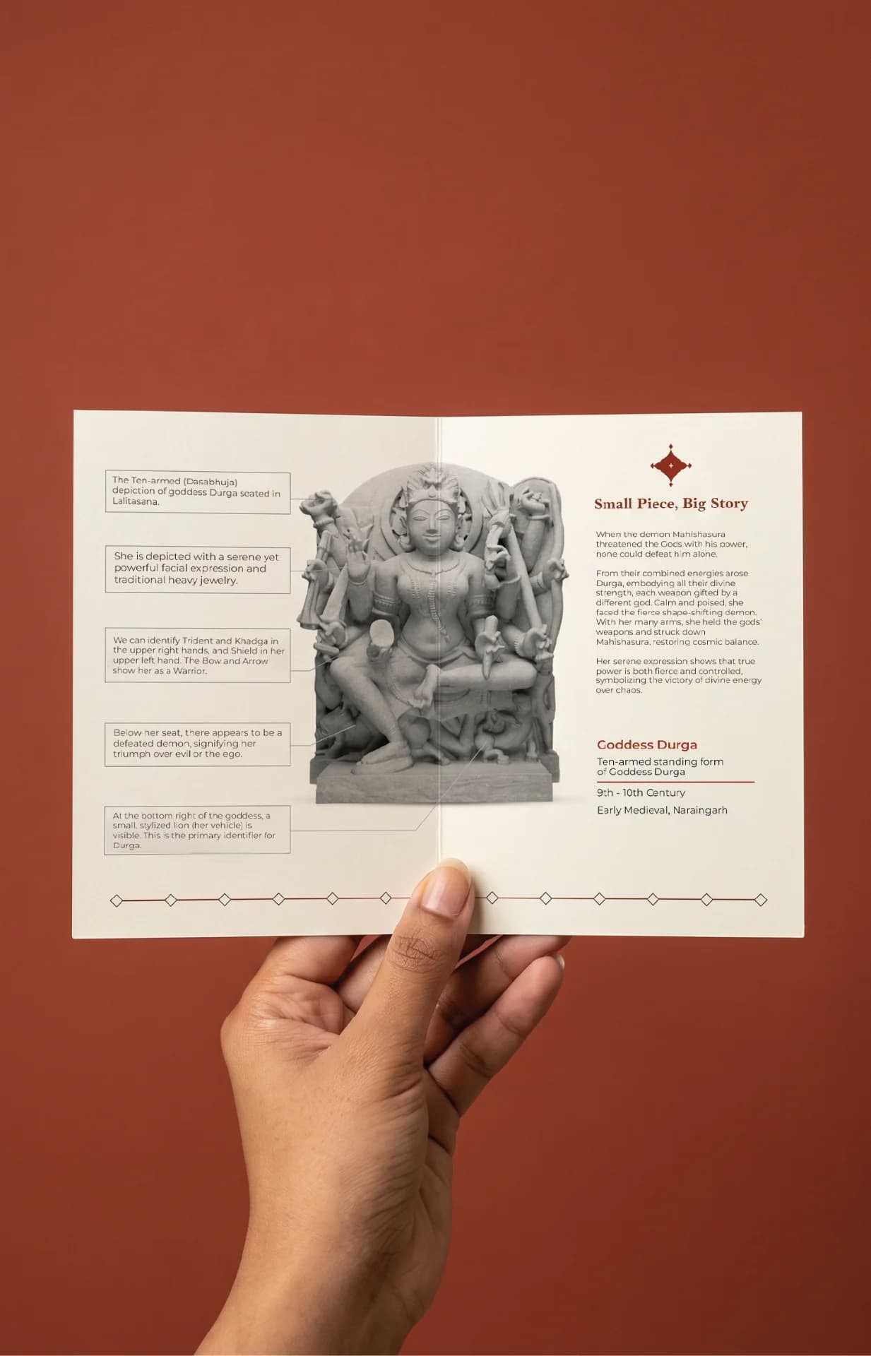 A hand holds an informational brochure featuring the Goddess Durga Sculpture, highlighting its stone-carved details and historical significance.