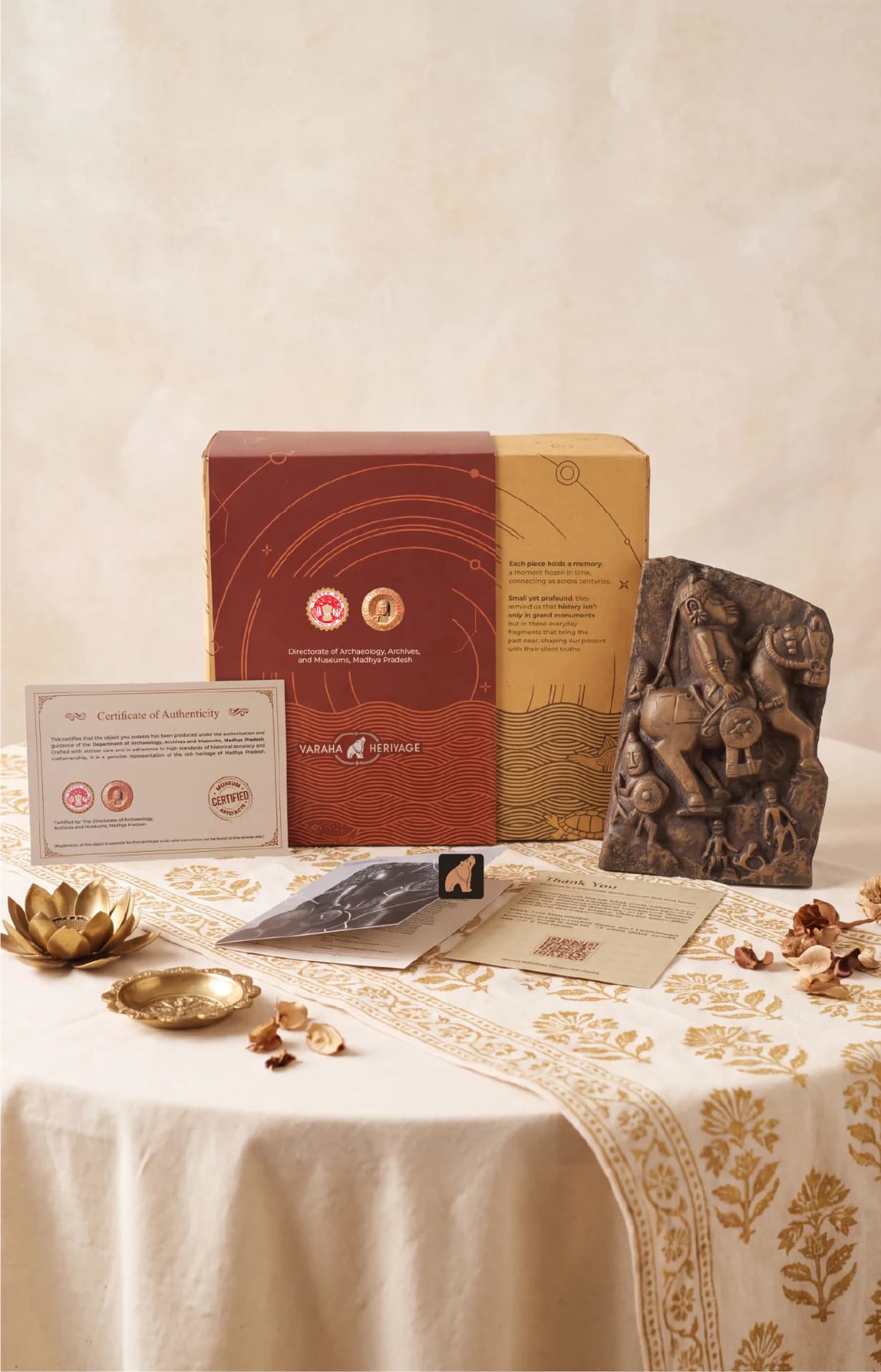 The Goud Yoddha stone sculpture displayed alongside its museum-certified packaging, authenticity certificate, and informational cards on a table.