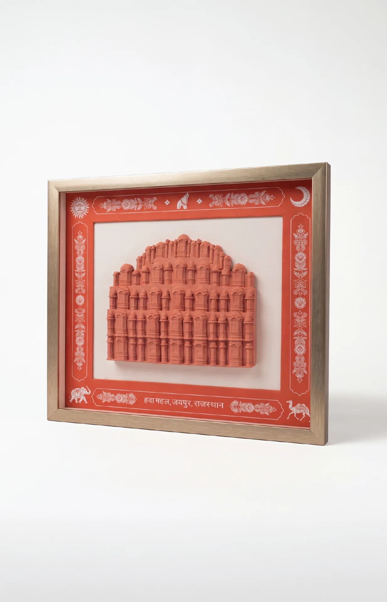 A three-quarter view of the Hawa Mahal Facade Sculpture, a terracotta-toned relief framed in a decorative gold border.