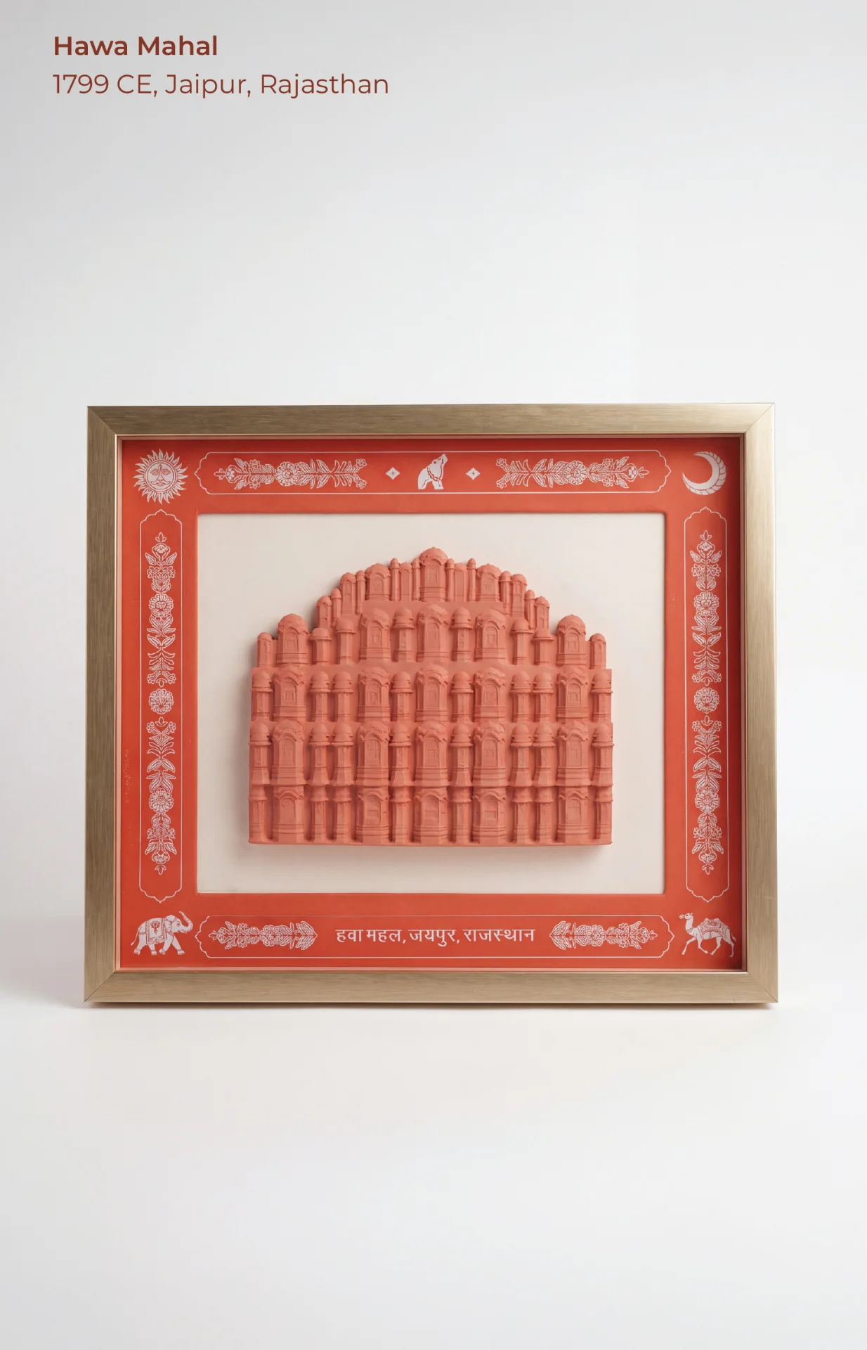 A framed Hawa Mahal Facade Sculpture featuring intricate terracotta-colored relief work set against a decorative red and cream border.