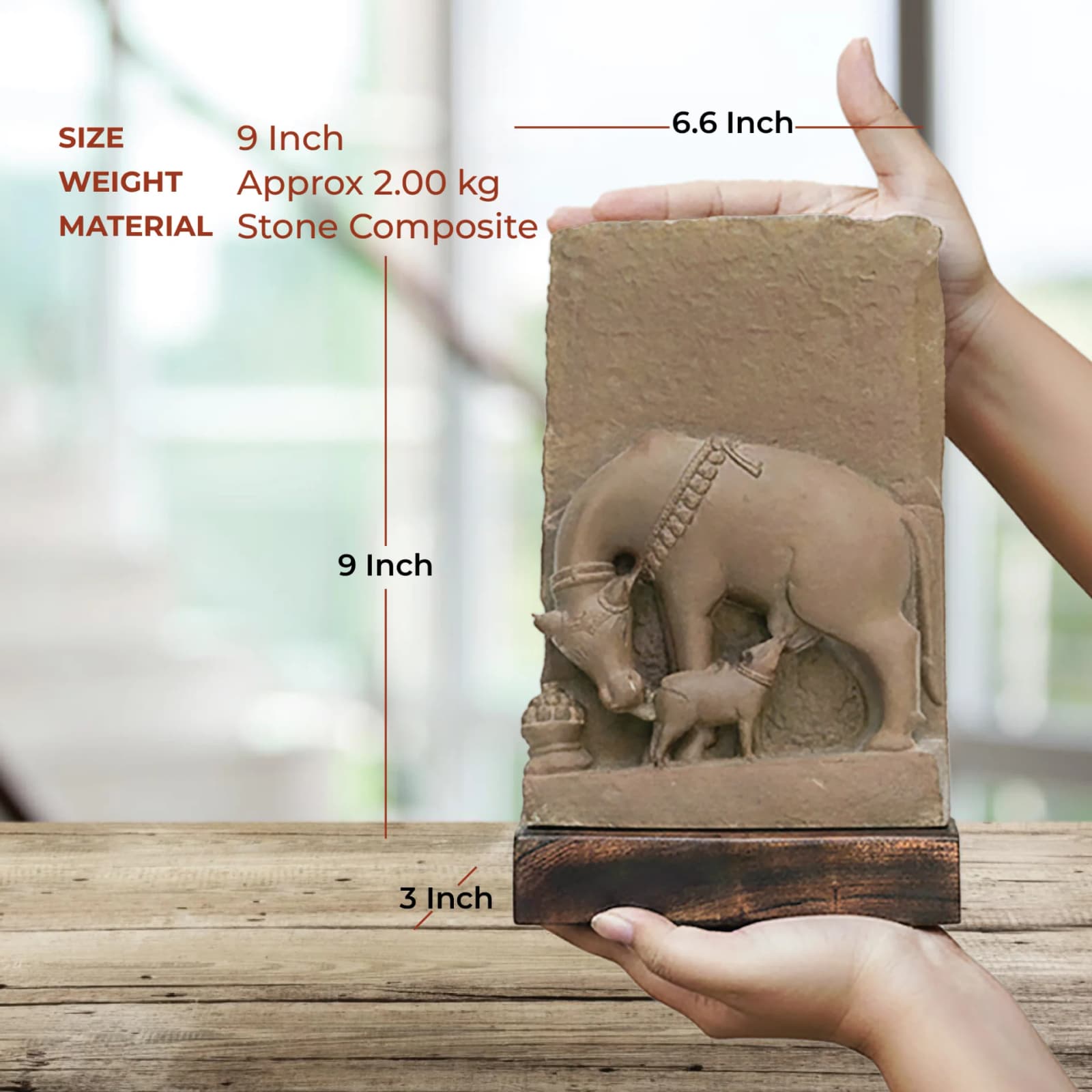 Hands holding a stone composite Kamdhenu Sculpture to demonstrate its size and dimensions against a blurred background.