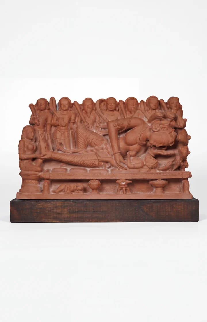 A terracotta-style Krishna's Birth Sculpture replica showing Devaki cradling her newborn beneath a multi-hooded serpent with standing soldiers.