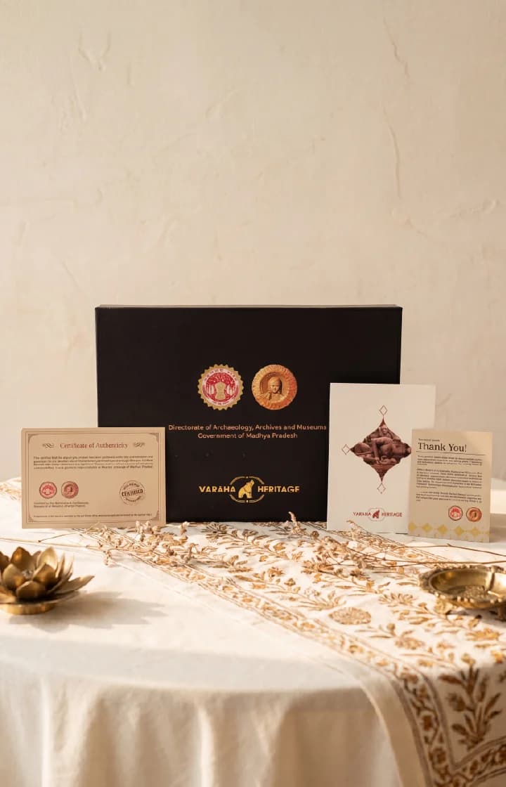 A Krishna's Birth Sculpture display box featuring official government certification and documentation on a decorated table setting.