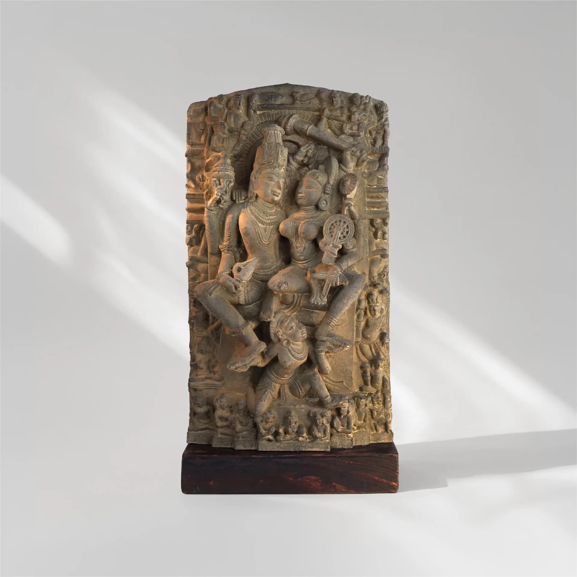 A front view of the Lakshmi Narayan Sculpture featuring intricate stone-carved details of the divine couple on a wooden base.