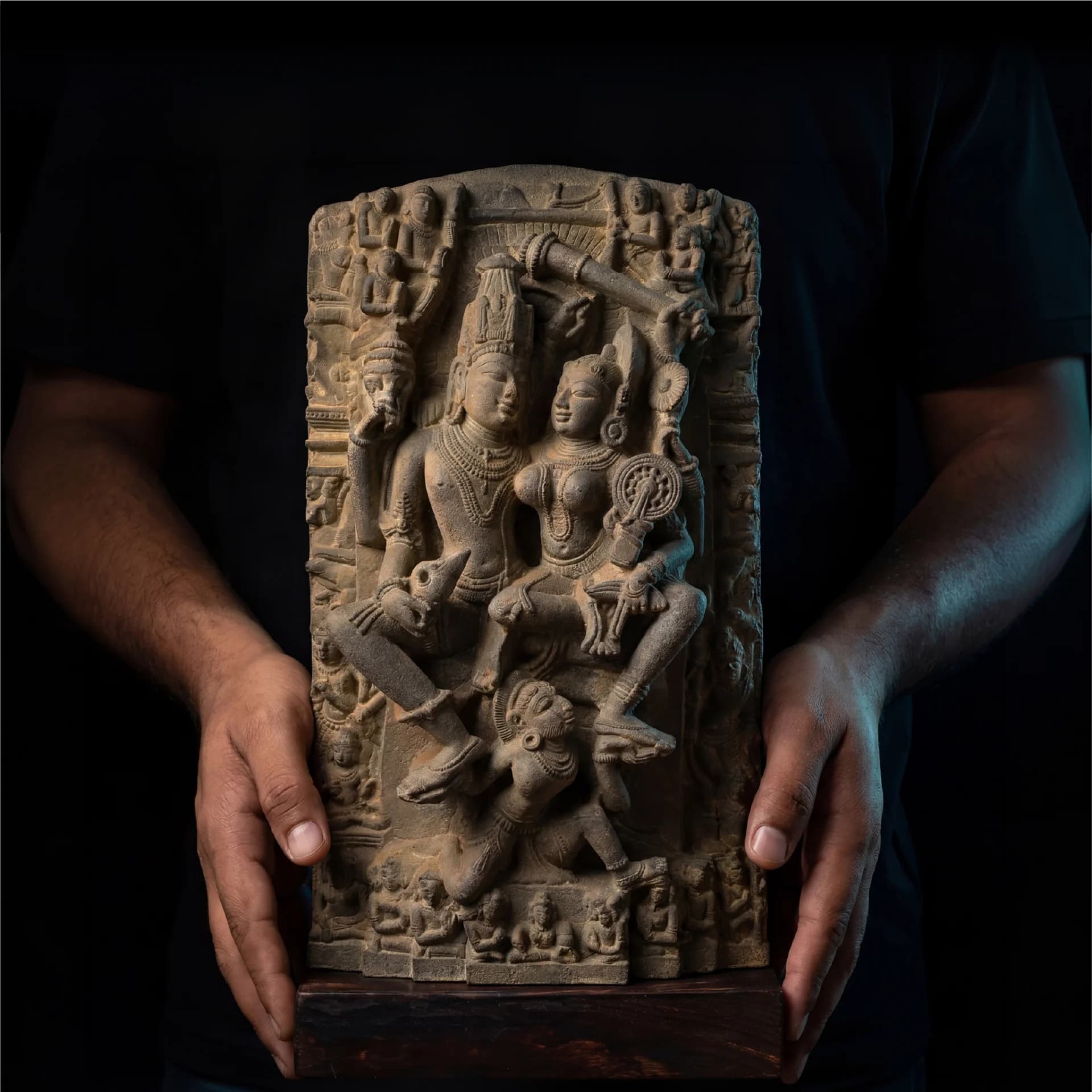 A person holds a detailed Lakshmi Narayan Sculpture, showcasing the intricate stone-carved texture of this 12th-century museum replica.