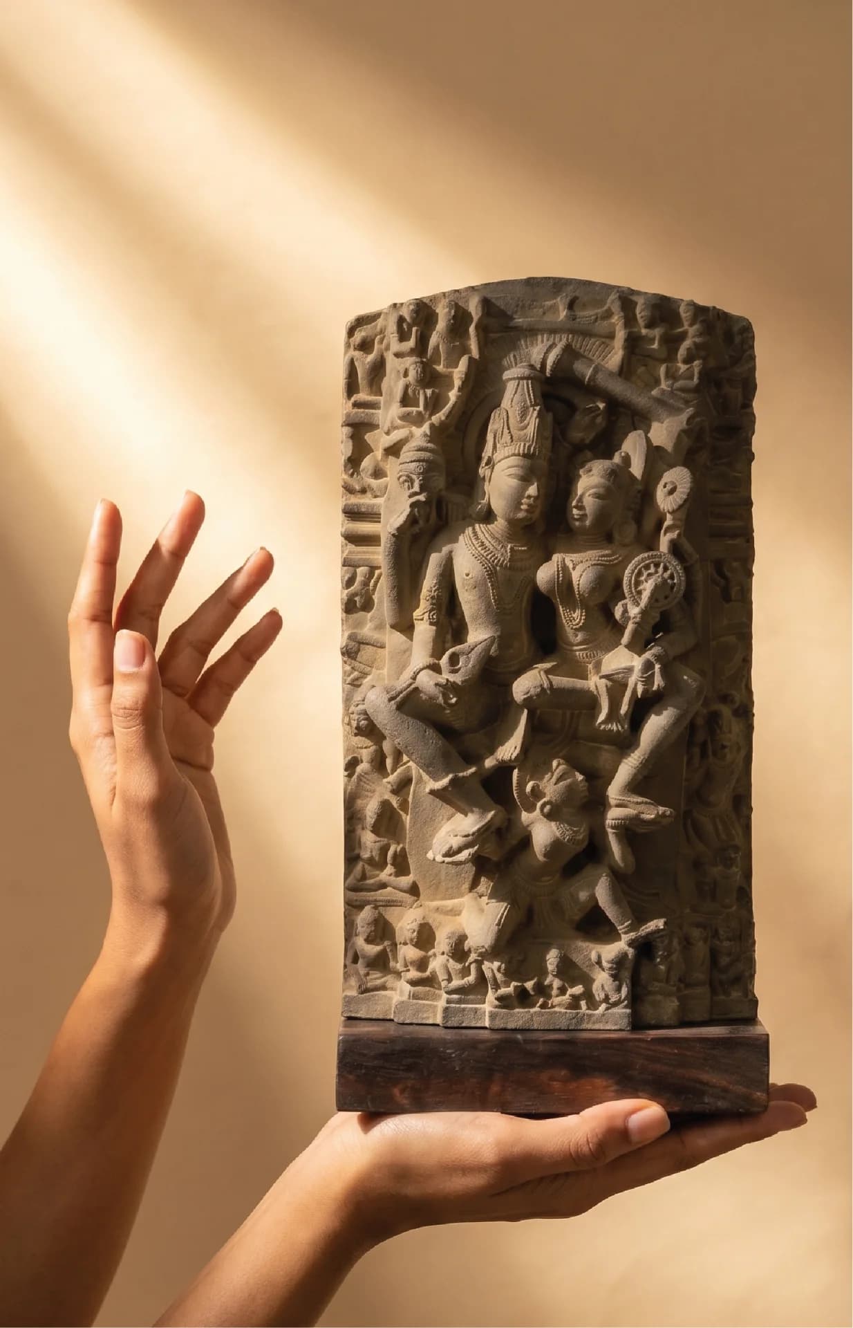 A pair of hands holds the Lakshmi Narayan Sculpture, a detailed stone composite replica featuring intricate medieval Indian iconography.