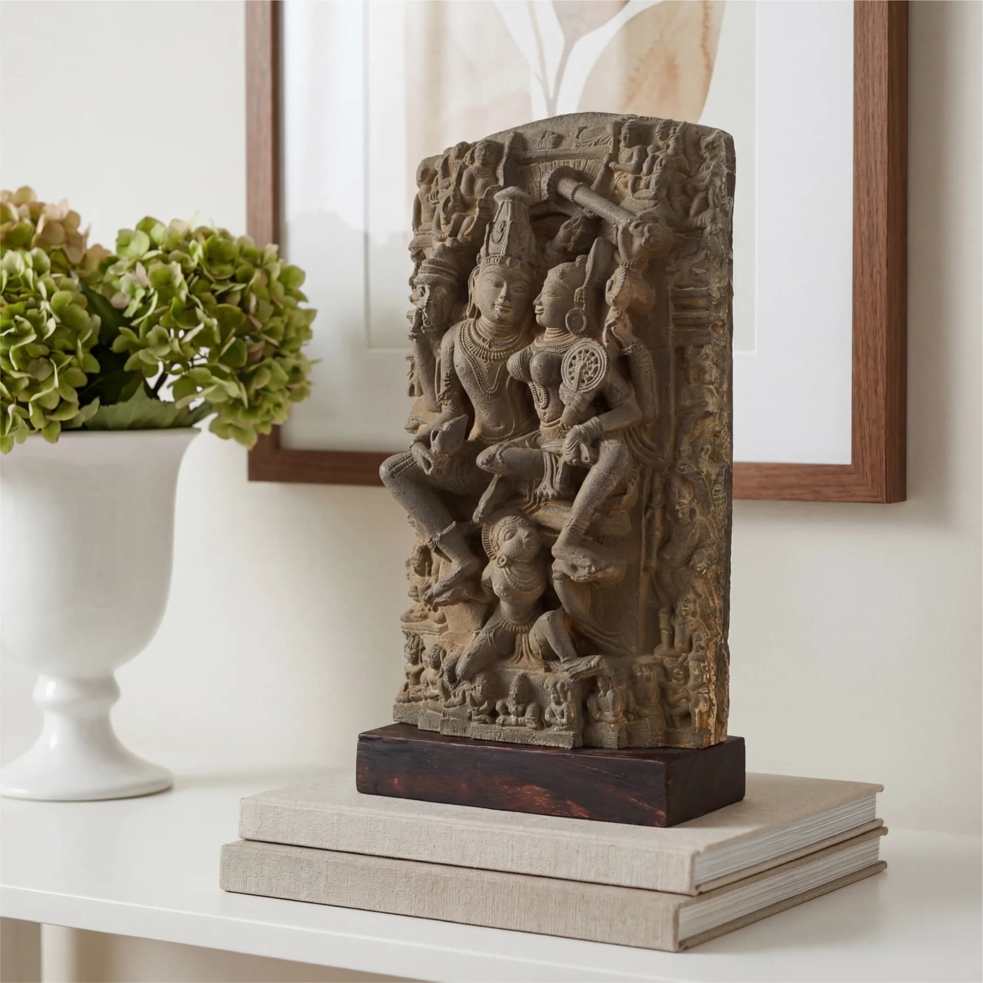 The Lakshmi Narayan Sculpture is displayed on books, featuring intricate stone-carved details of the deities in a museum-replica style.