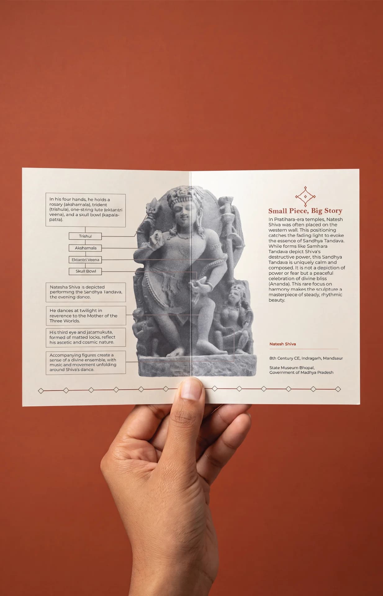 A hand holds an informational card featuring the Natesh Shiva Sculpture, highlighting its stone composite details and historical significance.