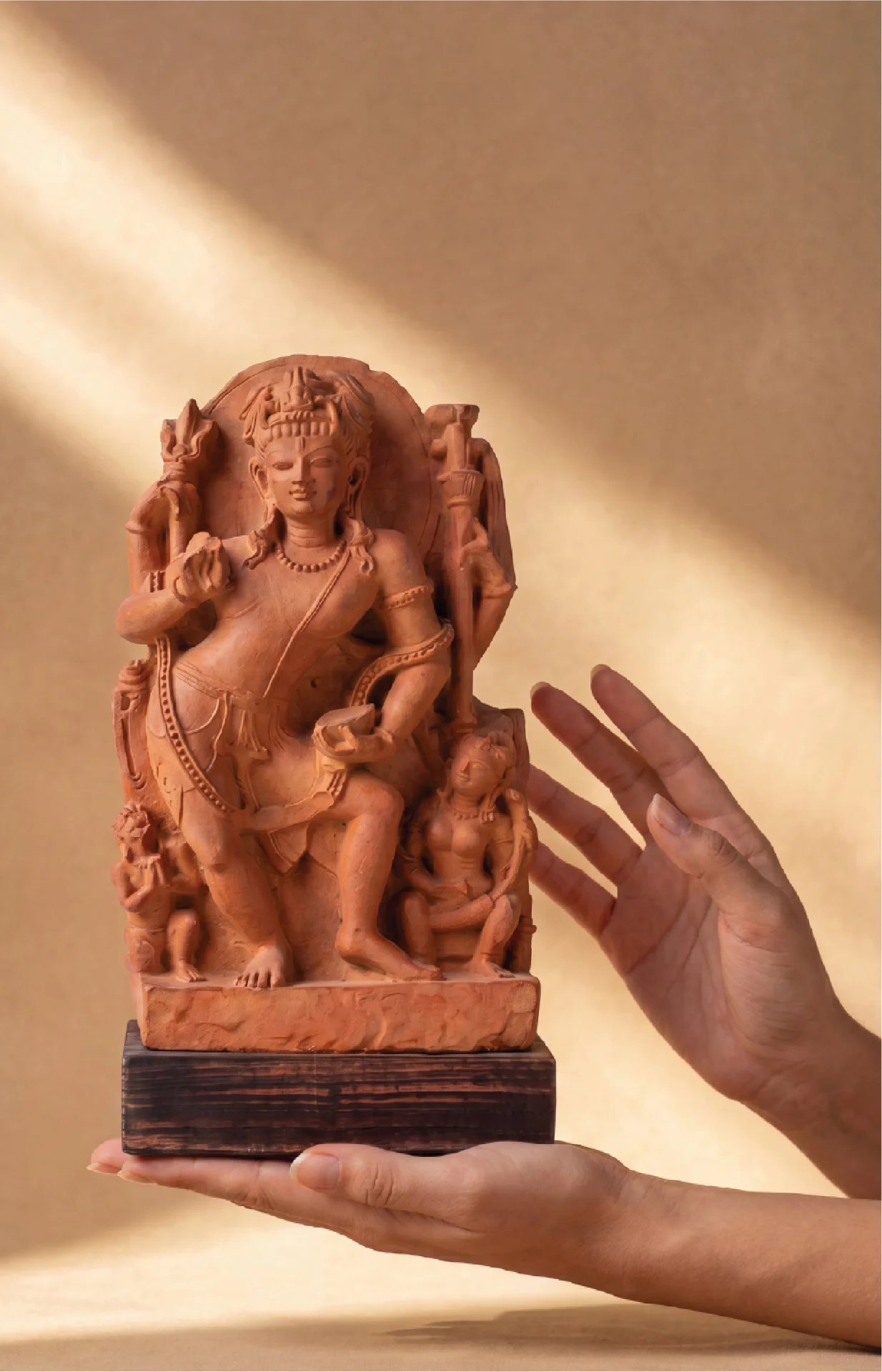 A pair of hands holds a hand-finished stone composite Natesh Shiva Sculpture, showcasing its intricate 8th-century style details.